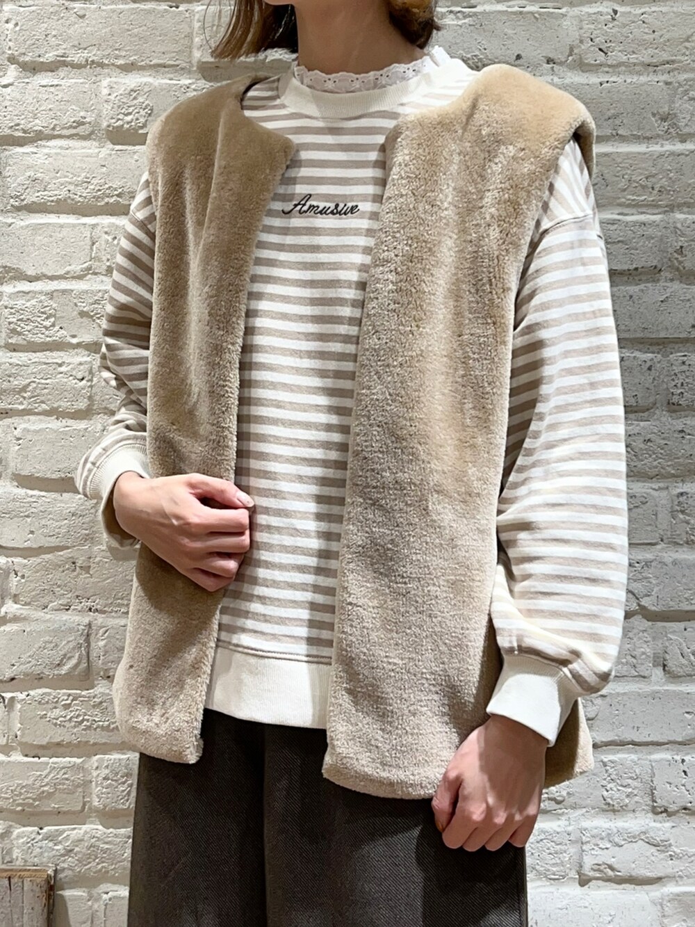 ホワイト系のTシャツ/カットソー、ホワイト系のニット/セーター、ホワイト系のブルゾンを着用したレディースの冬コーディネートの2枚目の写真