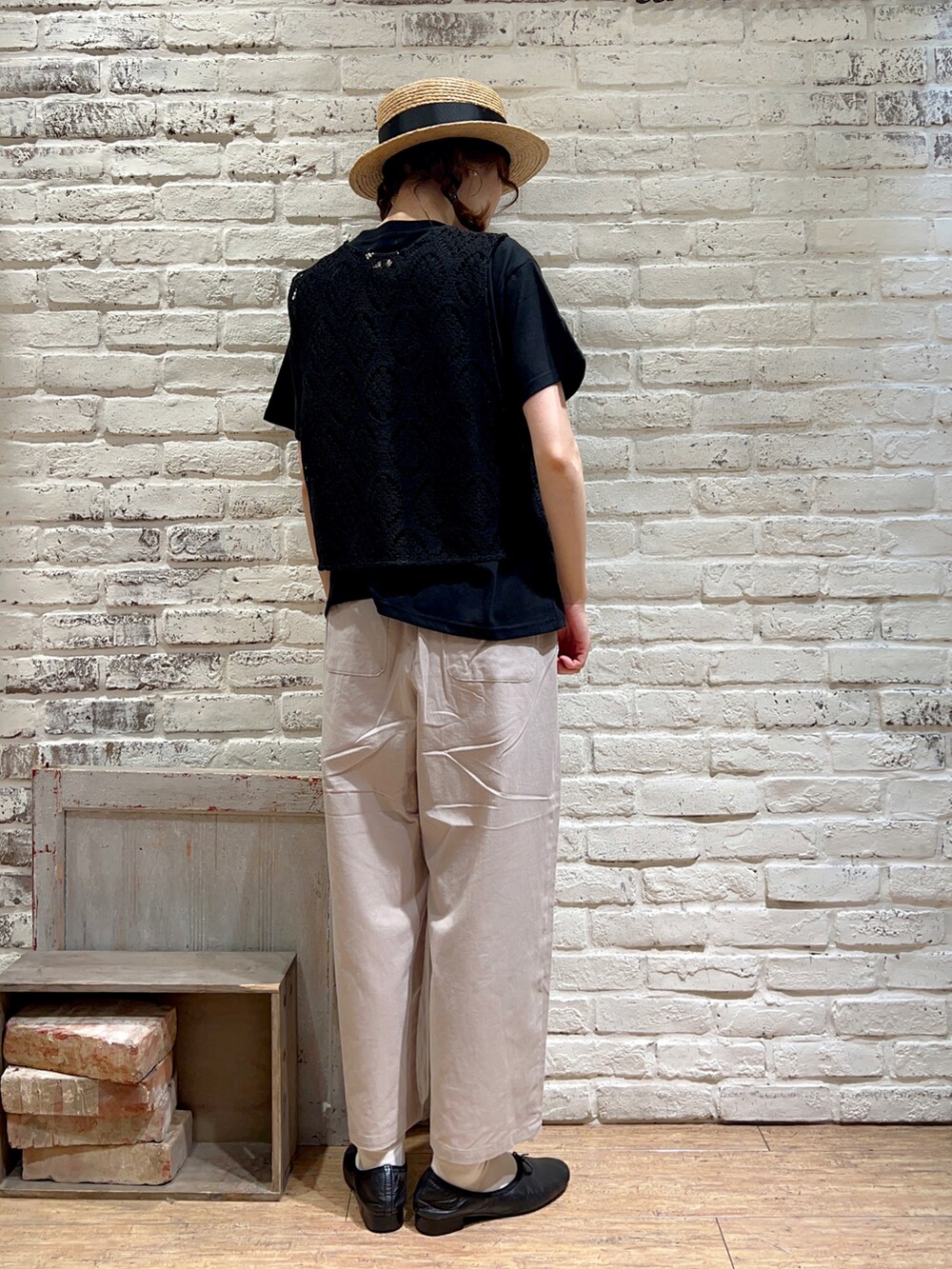 ブラック系のTシャツ/カットソー、ブラック系のベスト、ブラウン系のハンドバッグを着用したレディースの秋コーディネートの4枚目の写真