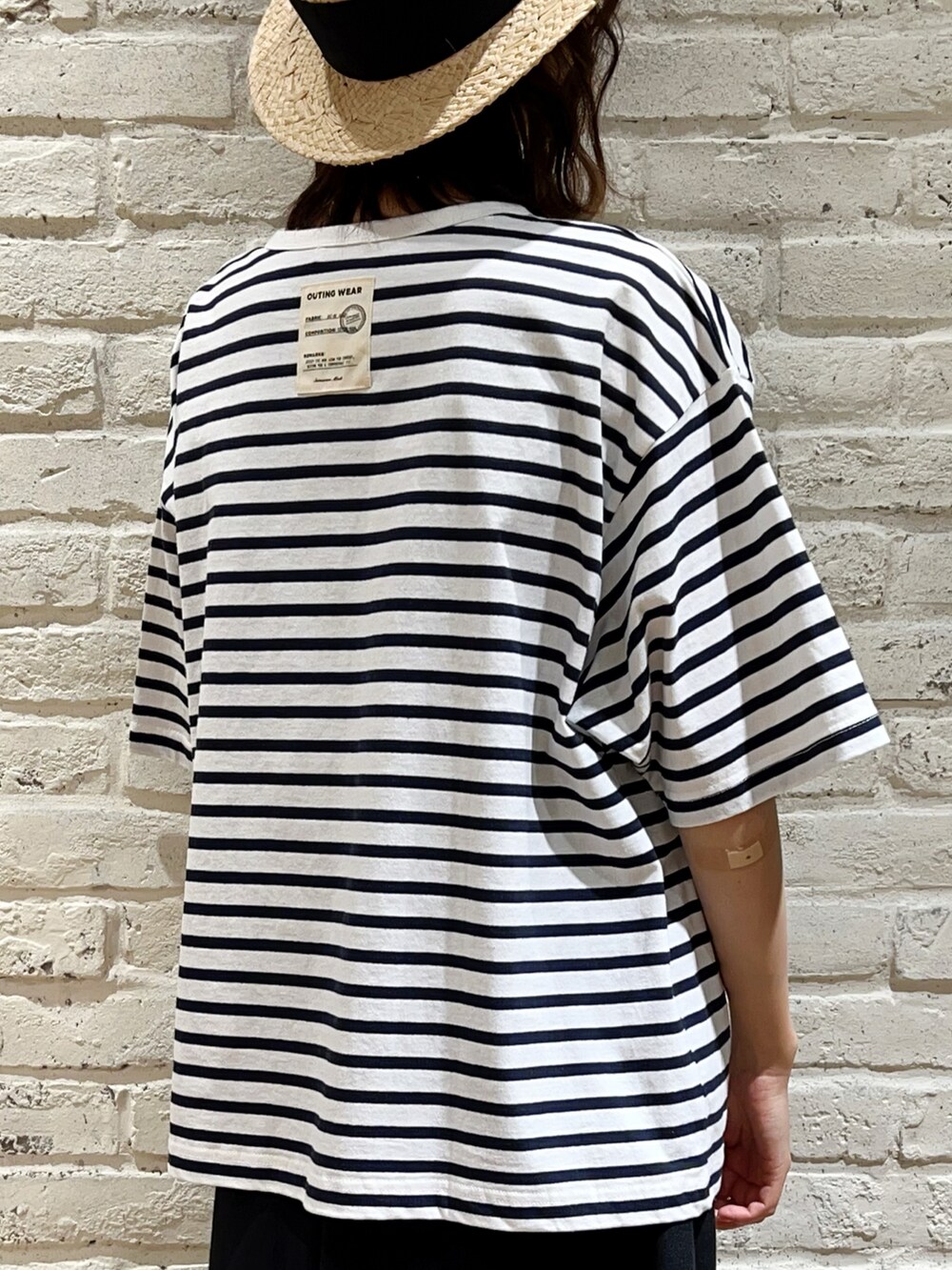 ホワイト系のTシャツ/カットソー、ベージュ系のベスト、ブラック系のハンドバッグを着用したレディースの春コーディネートの5枚目の写真