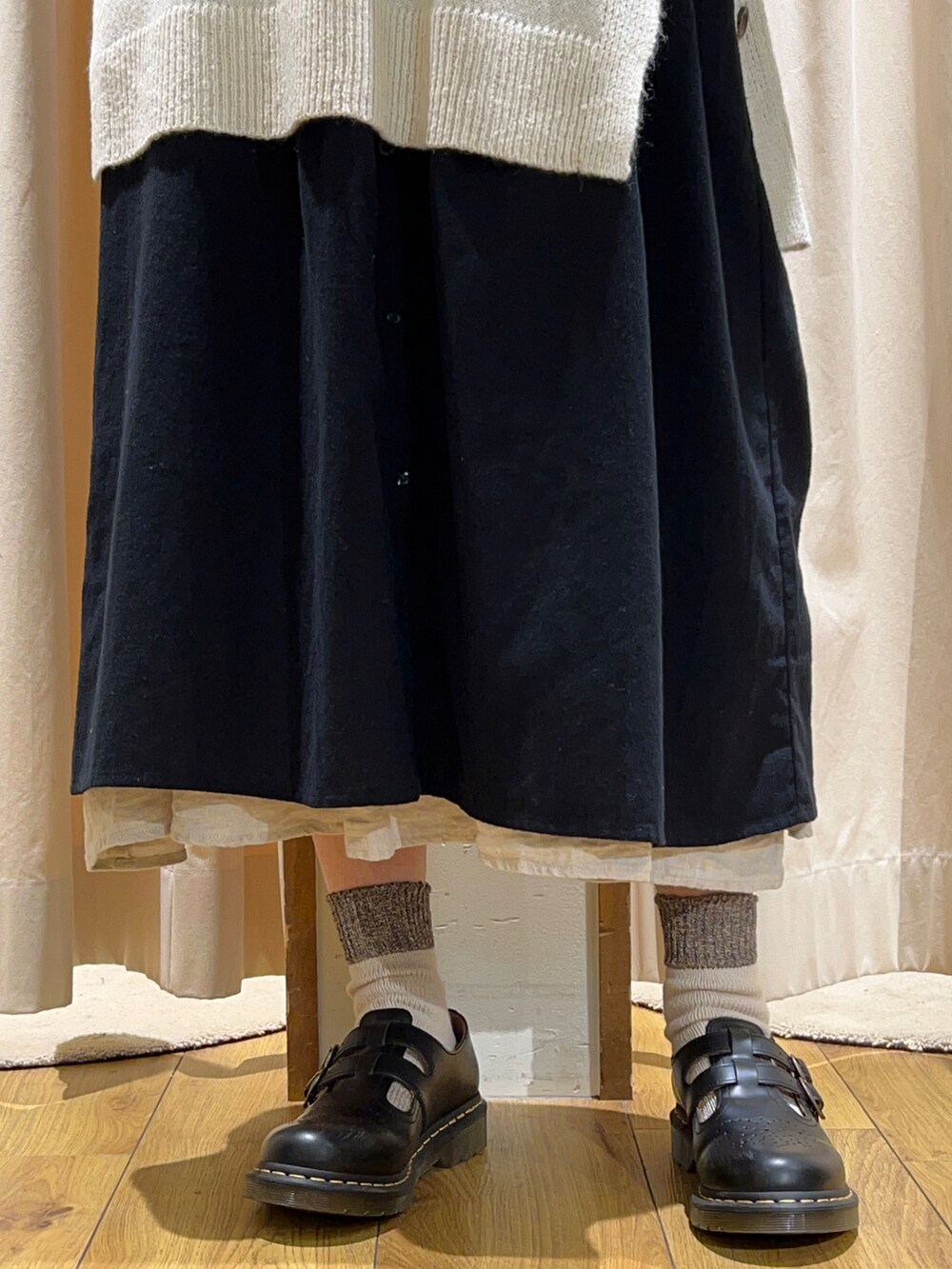 ホワイト系のTシャツ/カットソー、ホワイト系のベスト、ブラック系のワンピースを着用したレディースの冬コーディネートの5枚目の写真