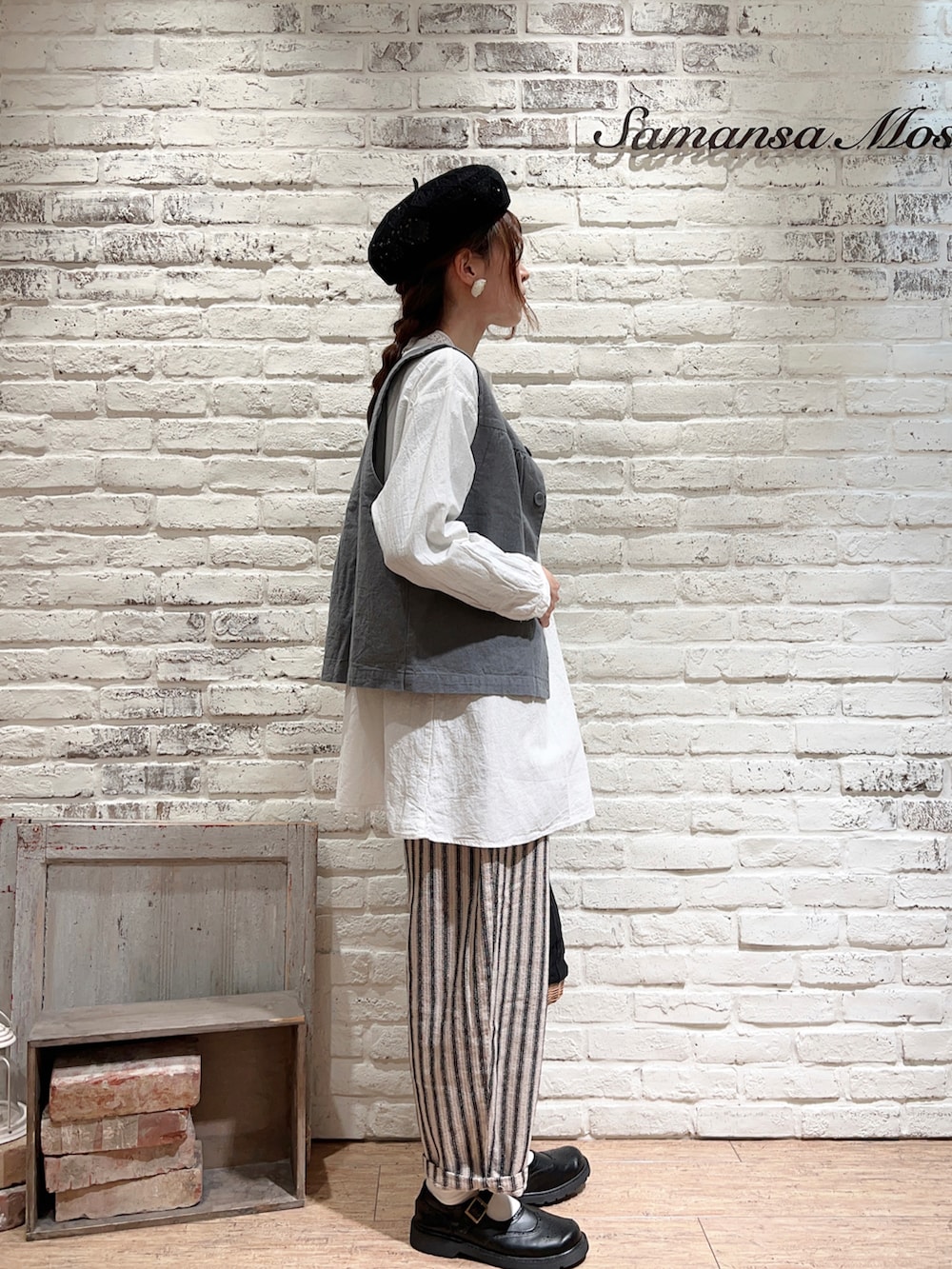 グリーン系のベスト、ホワイト系のシャツ/ブラウス、ブラック系のかごバッグを着用したレディースの春コーディネートの3枚目の写真