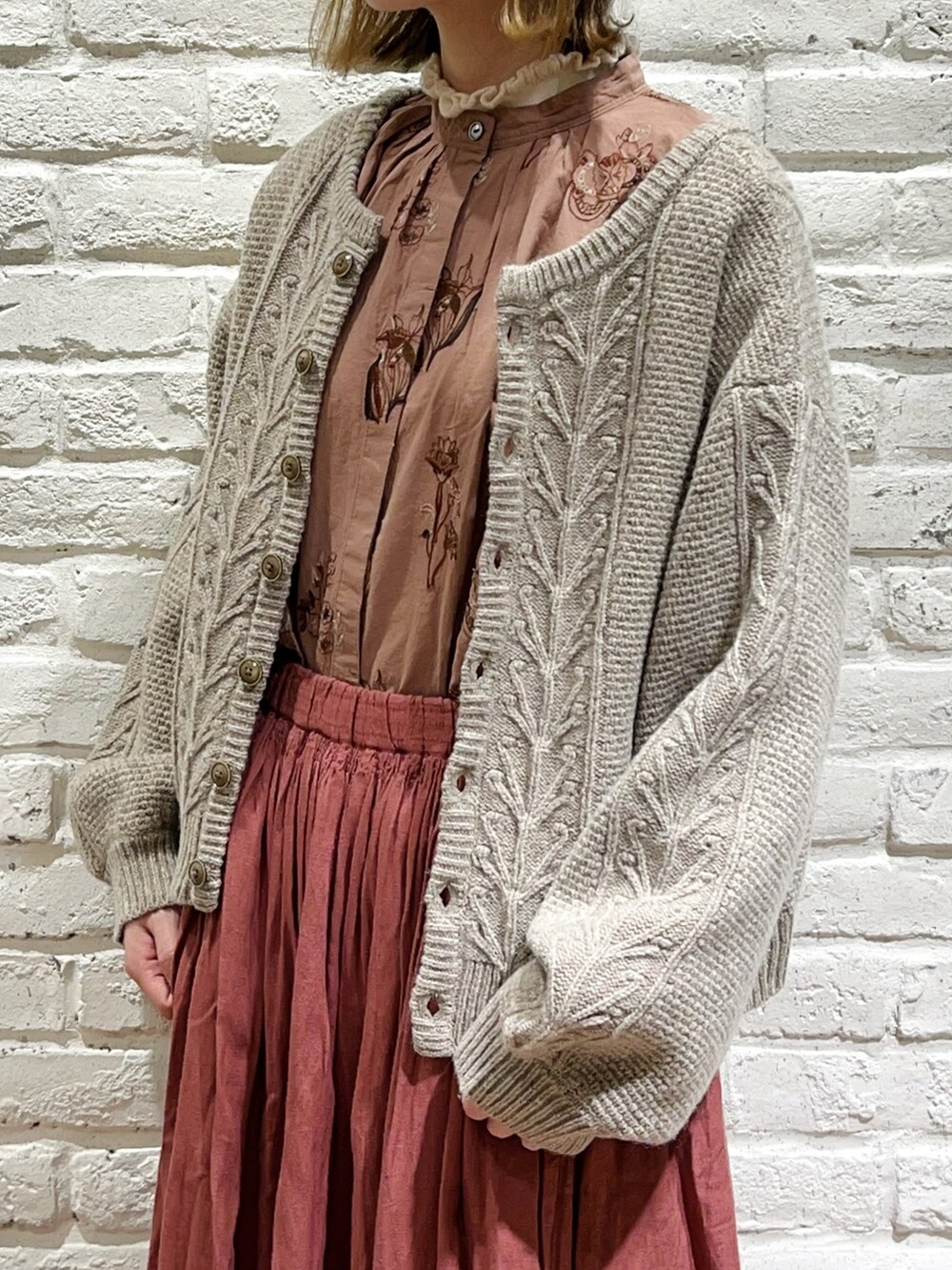 ホワイト系のニット/セーター、ベージュ系のカーディガン/ボレロ、ベージュ系のスカートを着用したレディースの秋コーディネートの2枚目の写真