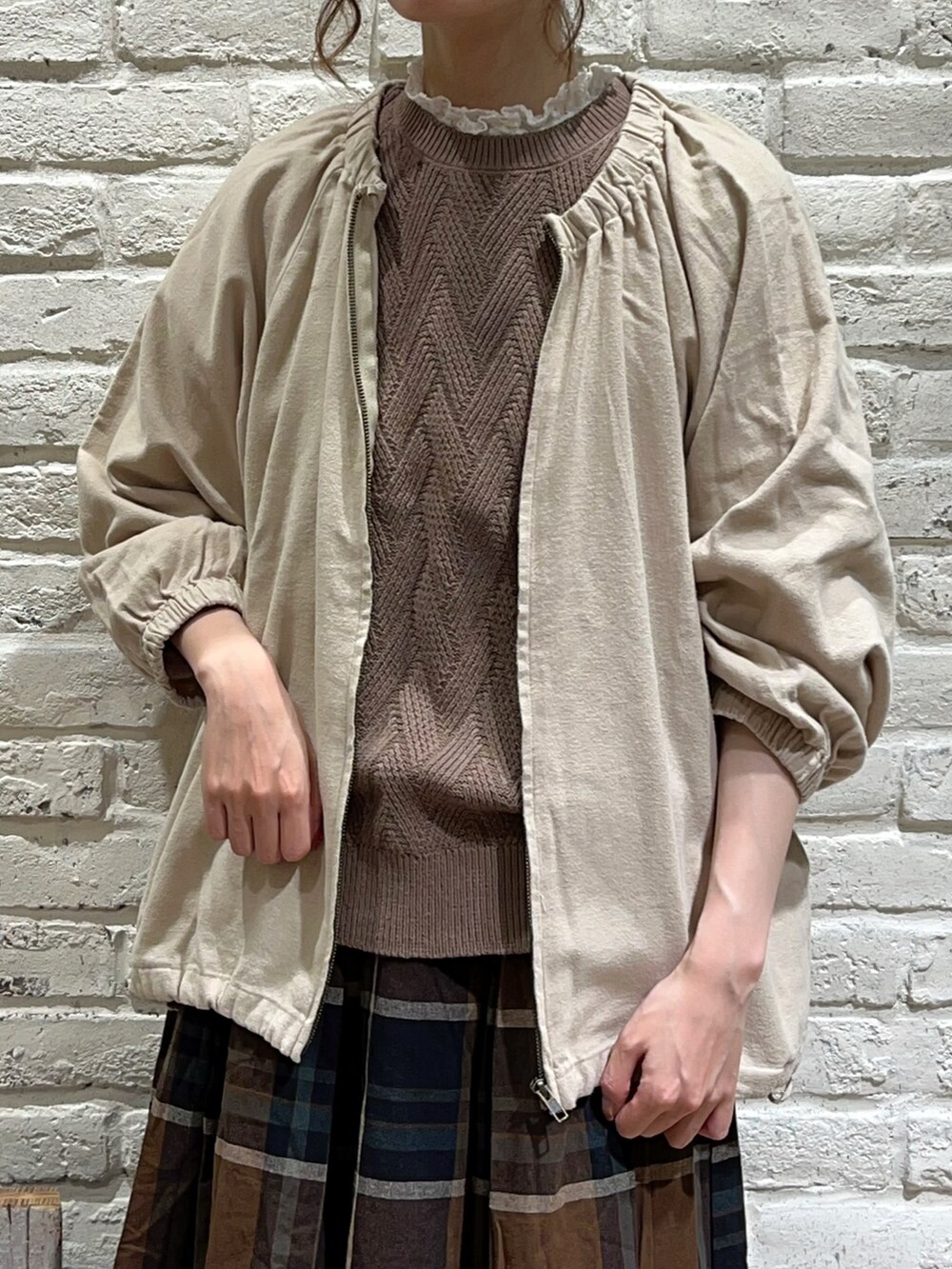 ホワイト系のシャツ/ブラウス、ベージュ系のブルゾン、ブラウン系のベストを着用したレディースの秋コーディネートの2枚目の写真