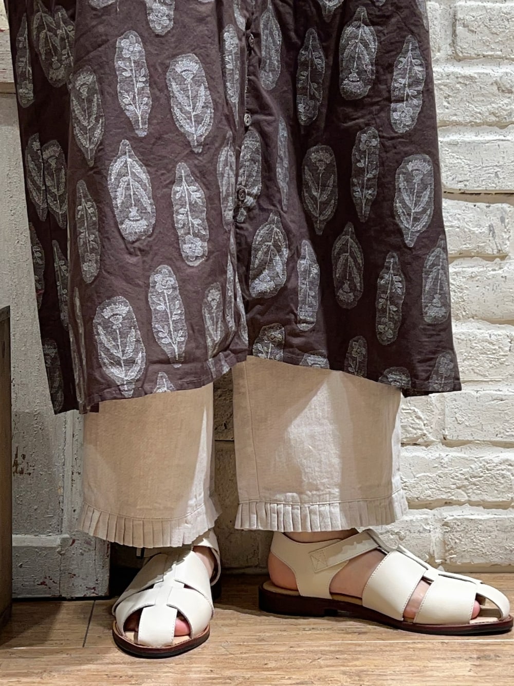 ブラウン系のワンピース、ホワイト系のその他パンツ、ホワイト系のサンダルを着用したレディースの春コーディネートの5枚目の写真