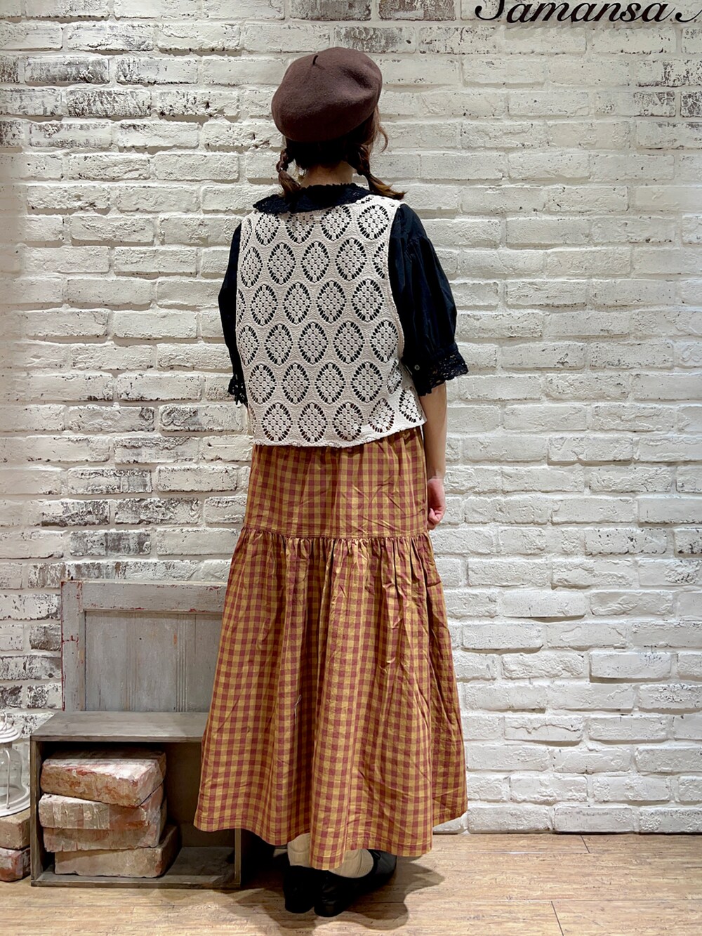 ホワイト系のベスト、ブラック系のシャツ/ブラウス、オレンジ系のスカートを着用したレディースの秋コーディネートの3枚目の写真