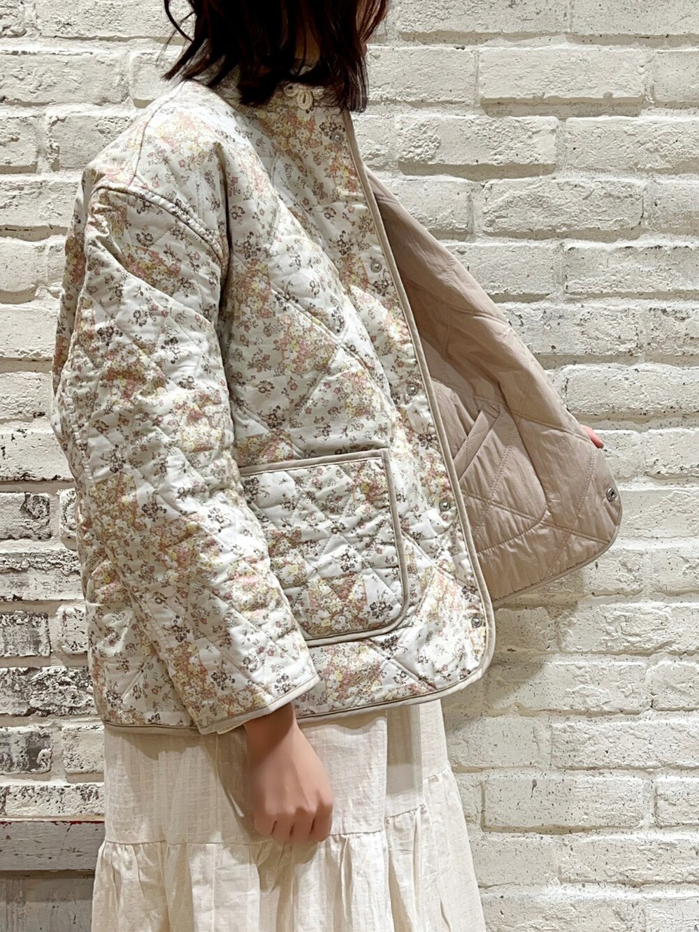 ホワイト系のニット/セーター、ベージュ系のノーカラージャケット、ホワイト系のワンピースを着用したレディースの冬コーディネートの3枚目の写真