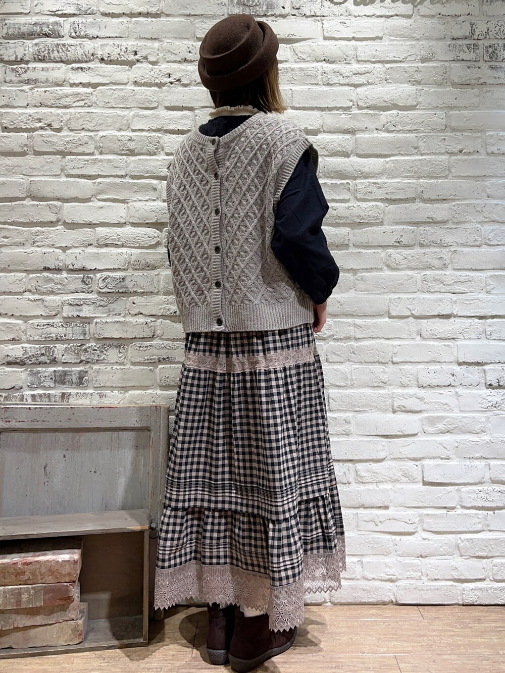 ホワイト系のニット/セーター、ベージュ系のベスト、ブラック系のシャツ/ブラウスを着用したレディースの秋コーディネートの4枚目の写真