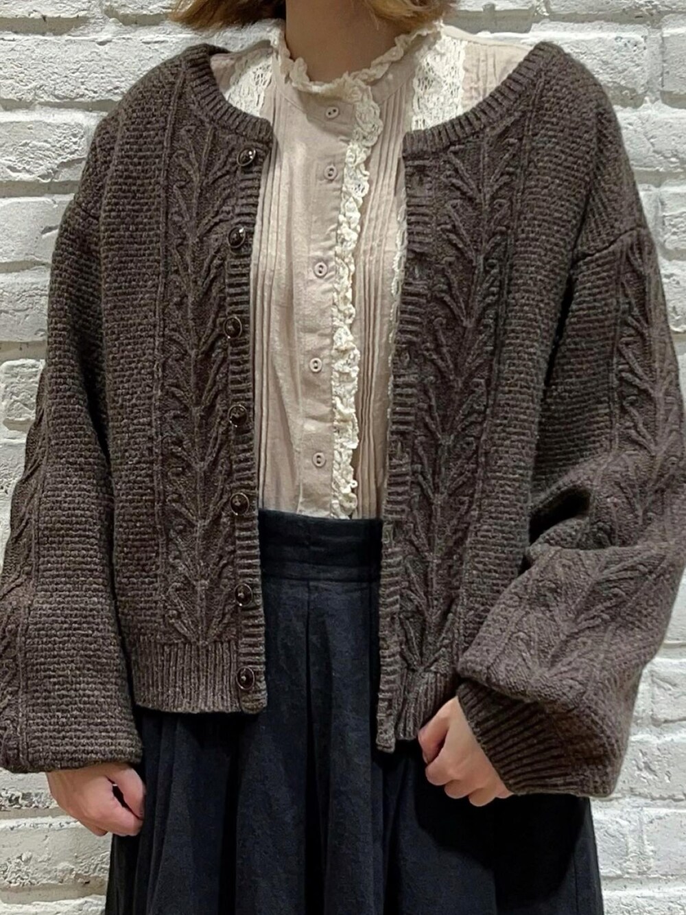 ホワイト系のシャツ/ブラウス、ブラウン系のカーディガン/ボレロ、ブラック系のスカートを着用したレディースの秋コーディネートの2枚目の写真