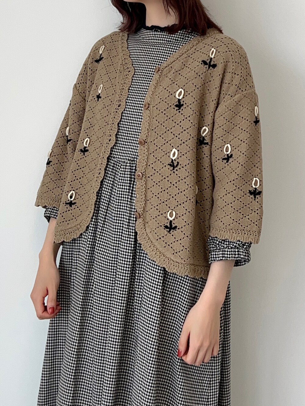 ベージュ系のカーディガン/ボレロ、ベージュ系のワンピース、ブラック系のサンダルを着用したレディースの春コーディネートの2枚目の写真