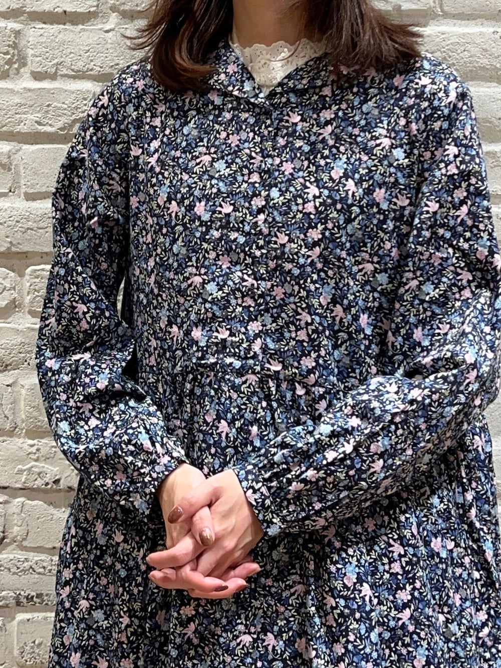 ホワイト系のタンクトップ、ピンク系のワンピース、ブラック系のスカートを着用したレディースの秋コーディネートの2枚目の写真