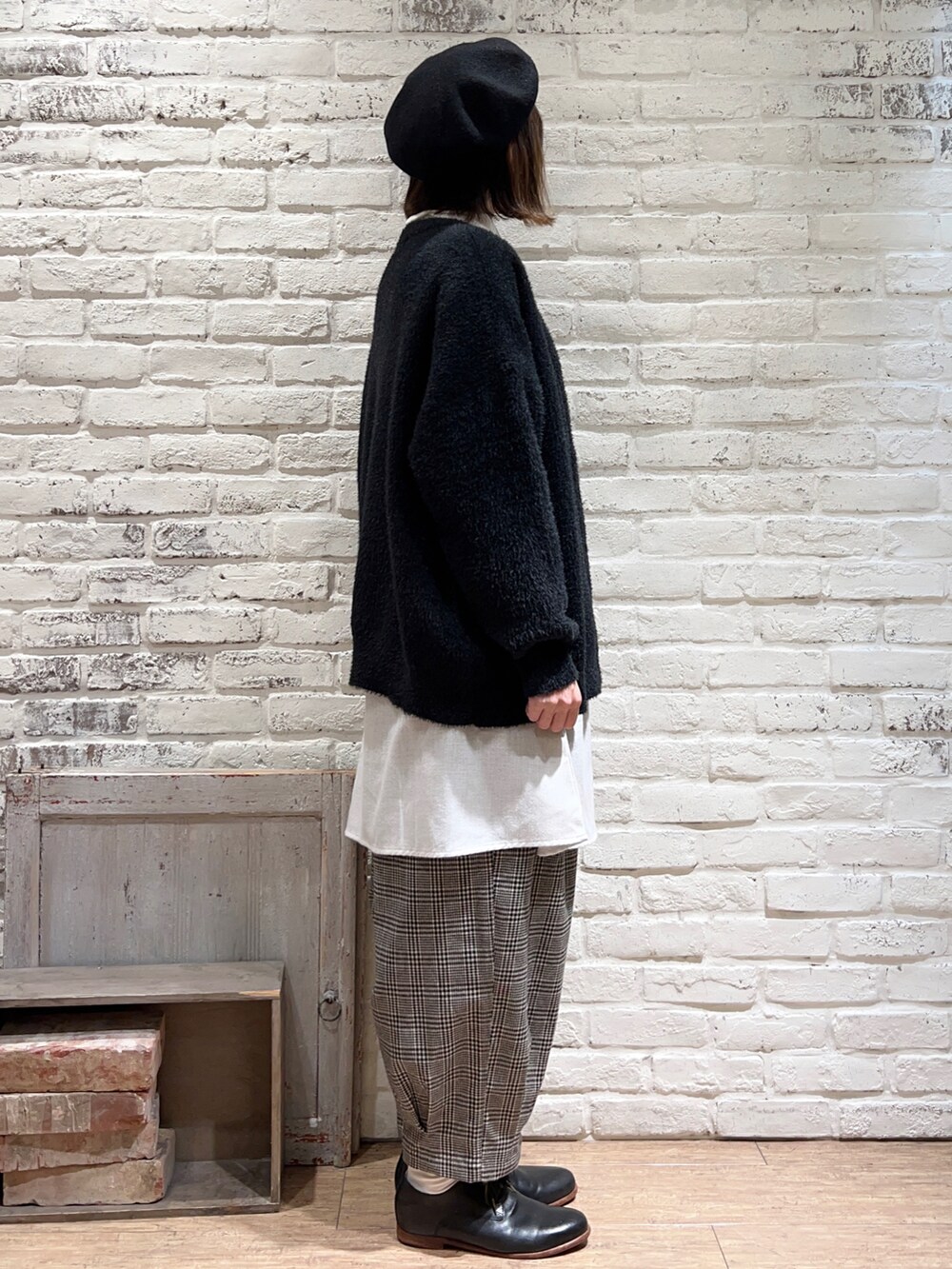 ホワイト系のニット/セーター、グレー系のチュニック、ブラック系のカーディガン/ボレロを着用したレディースの冬コーディネートの3枚目の写真