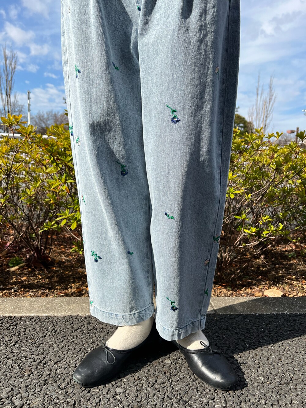 ブラック系のシャツ/ブラウス、ホワイト系のニット/セーター、ブルー系のデニムパンツを着用したレディースの冬コーディネートの3枚目の写真