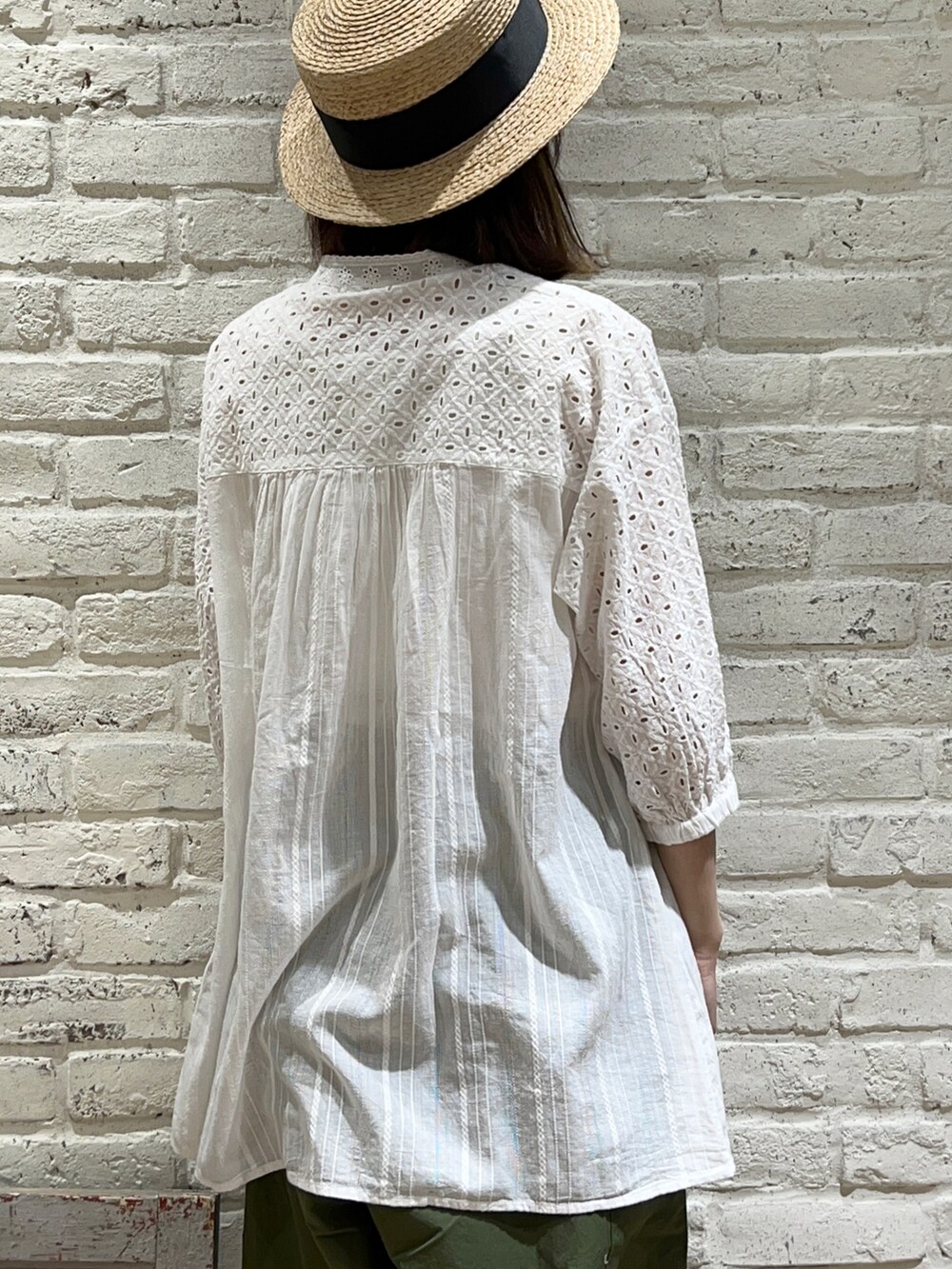 ホワイト系のチュニック、イエロー系のその他アウター、ブラック系のハンドバッグを着用したレディースの春コーディネートの5枚目の写真