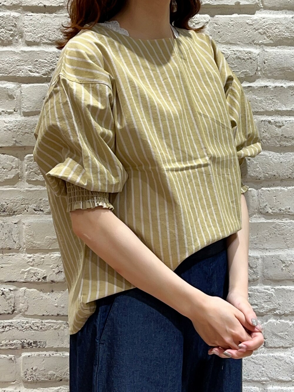ホワイト系のTシャツ/カットソー、イエロー系のシャツ/ブラウス、ブルー系のデニムパンツを着用したレディースの春コーディネートの2枚目の写真