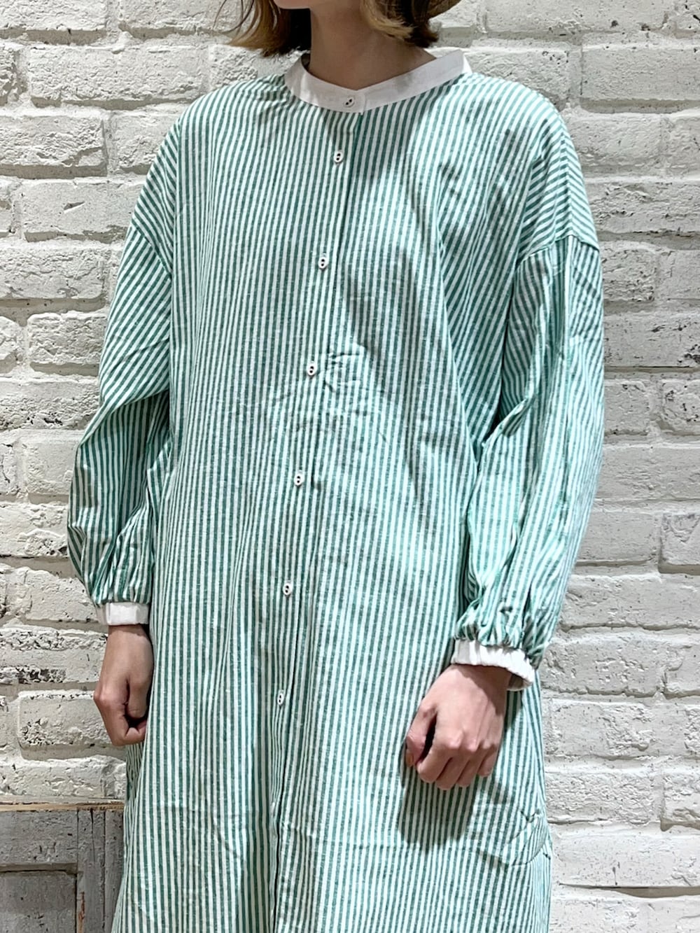 ホワイト系のニット/セーター、グリーン系のワンピース、ホワイト系のその他パンツを着用したレディースの冬コーディネートの2枚目の写真