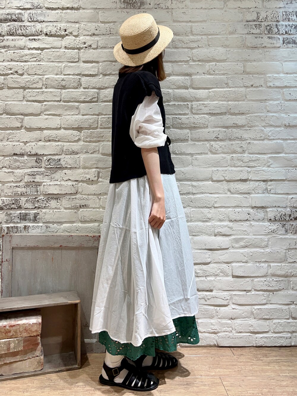 ホワイト系のタンクトップ、ブラック系のベスト、ホワイト系のワンピースを着用したレディースの春コーディネートの2枚目の写真