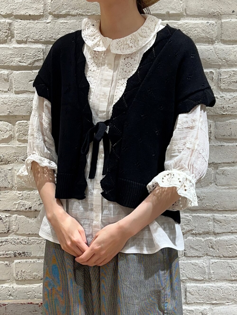 ホワイト系のシャツ/ブラウス、ブラック系のベスト、ブラック系のハンドバッグを着用したレディースの夏コーディネートの2枚目の写真