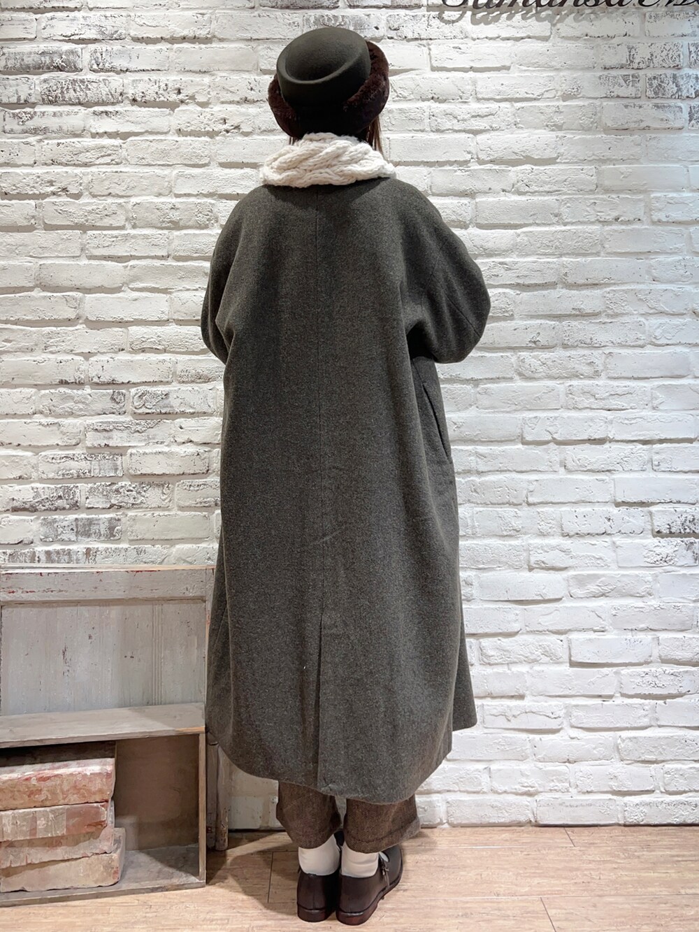 グリーン系のノーカラーコート、ホワイト系のシャツ/ブラウス、ブラウン系のその他パンツを着用したレディースの冬コーディネートの5枚目の写真