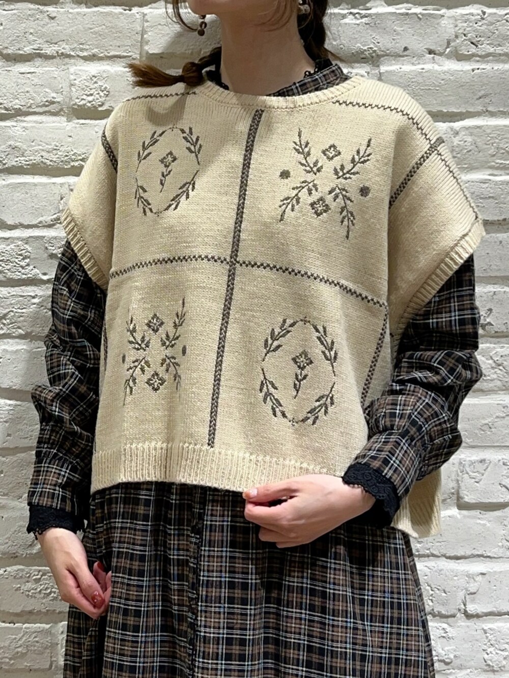 ホワイト系のベスト、ブラック系のTシャツ/カットソー、ブラウン系のワンピースを着用したレディースの秋コーディネートの2枚目の写真