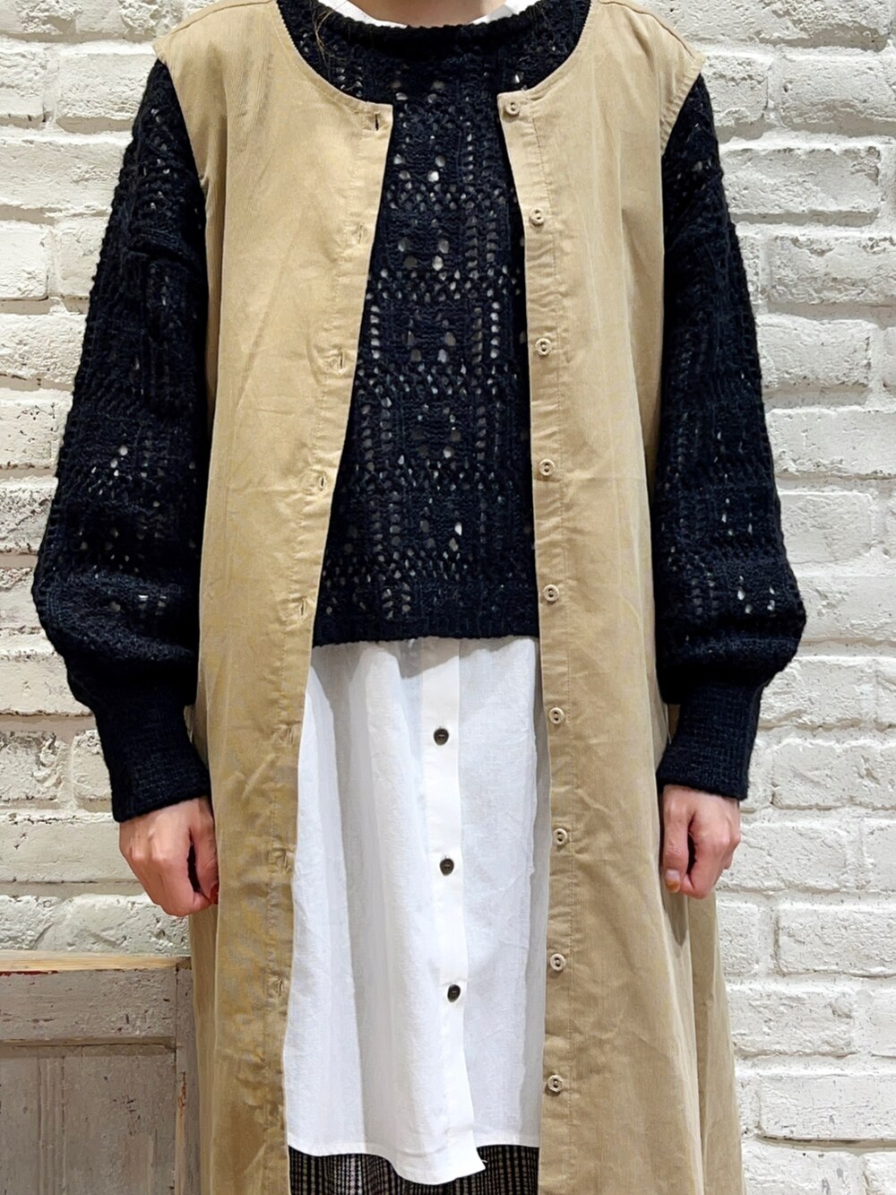 ブラック系のカーディガン/ボレロ、ベージュ系のジャンパースカート、ホワイト系のシャツ/ブラウスを着用したレディースの秋コーディネートの2枚目の写真