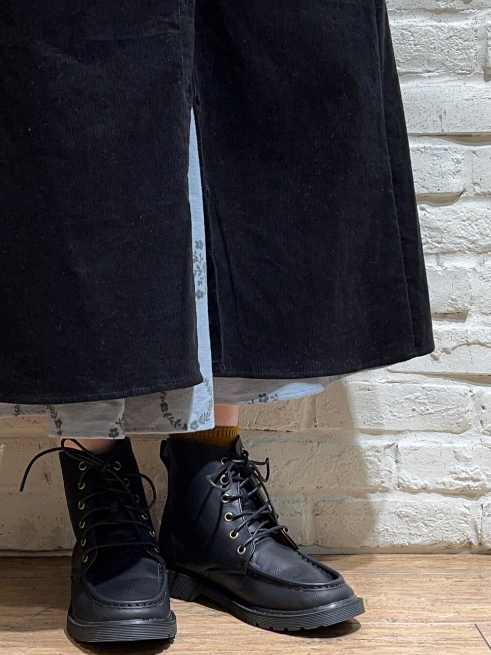 グレー系のTシャツ/カットソー、ブラック系のジャンパースカート、ブルー系のスカートを着用したレディースの秋コーディネートの5枚目の写真