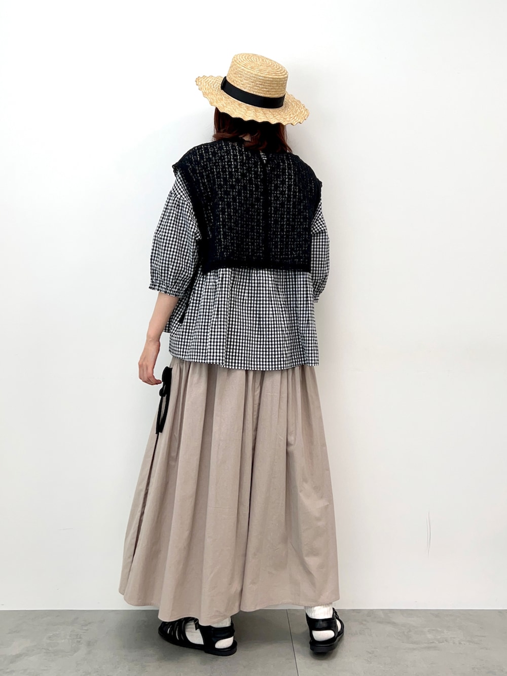 ベージュ系のワンピース、ベージュ系のスカート、ブラック系のサンダルを着用したレディースの春コーディネートの5枚目の写真