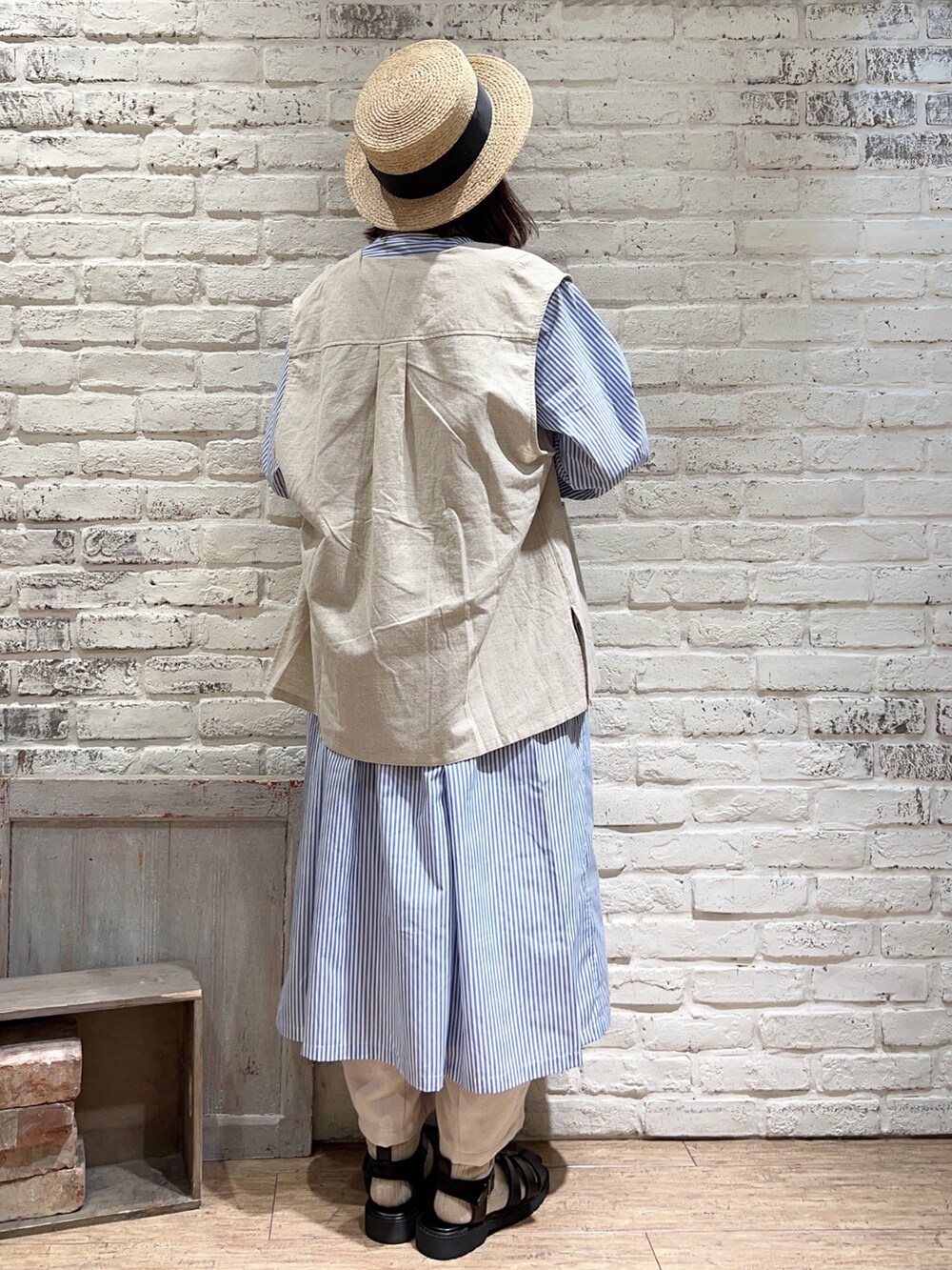 ホワイト系のベスト、ブラック系のハンドバッグ、ブルー系のシャツワンピースを着用したレディースの春コーディネートの4枚目の写真