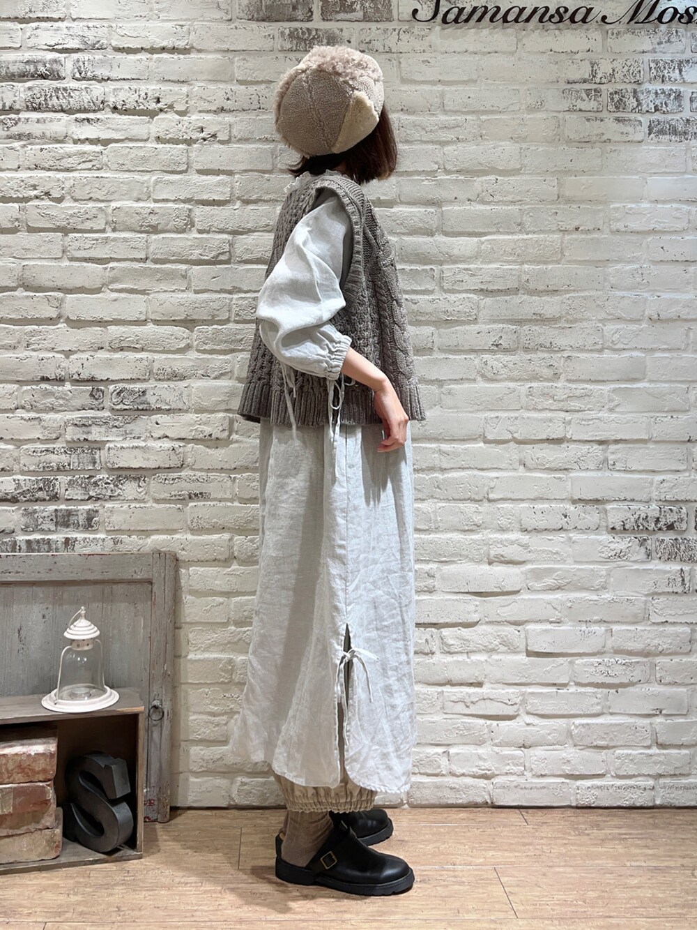 ホワイト系のTシャツ/カットソー、ブラウン系のベスト、グリーン系のワンピースを着用したレディースの冬コーディネートの2枚目の写真