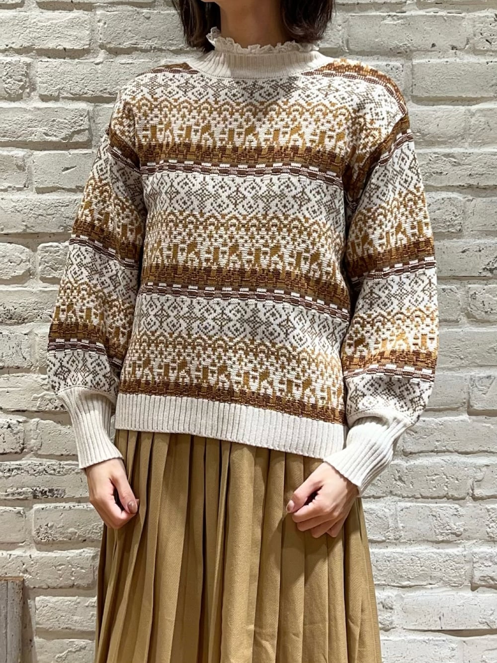 ホワイト系のシャツ/ブラウス、ホワイト系のニット/セーター、ベージュ系のスカートを着用したレディースの冬コーディネートの2枚目の写真