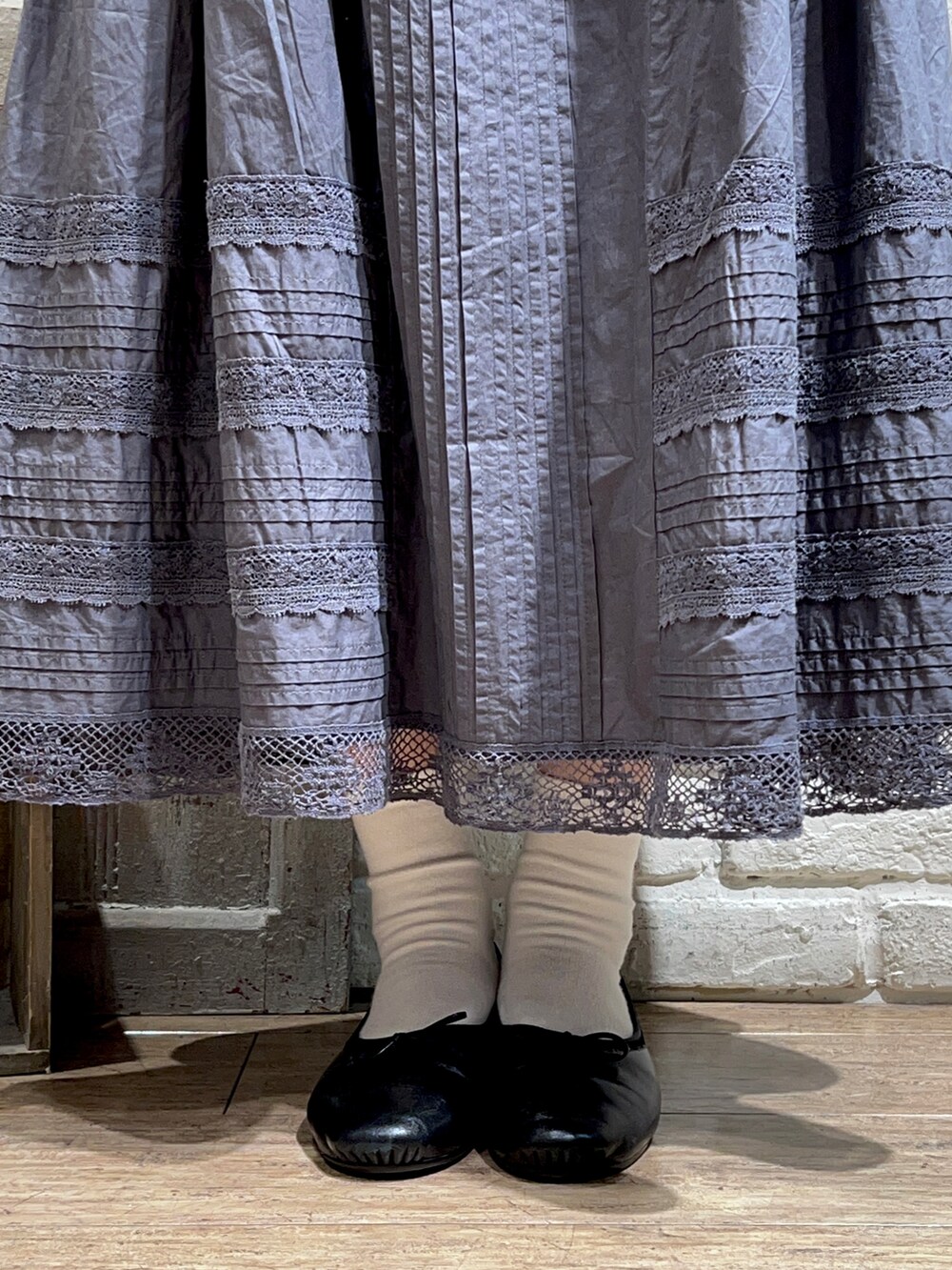 ホワイト系のカーディガン/ボレロ、グレー系のシャツ/ブラウス、グレー系のスカートを着用したレディースの春コーディネートの5枚目の写真