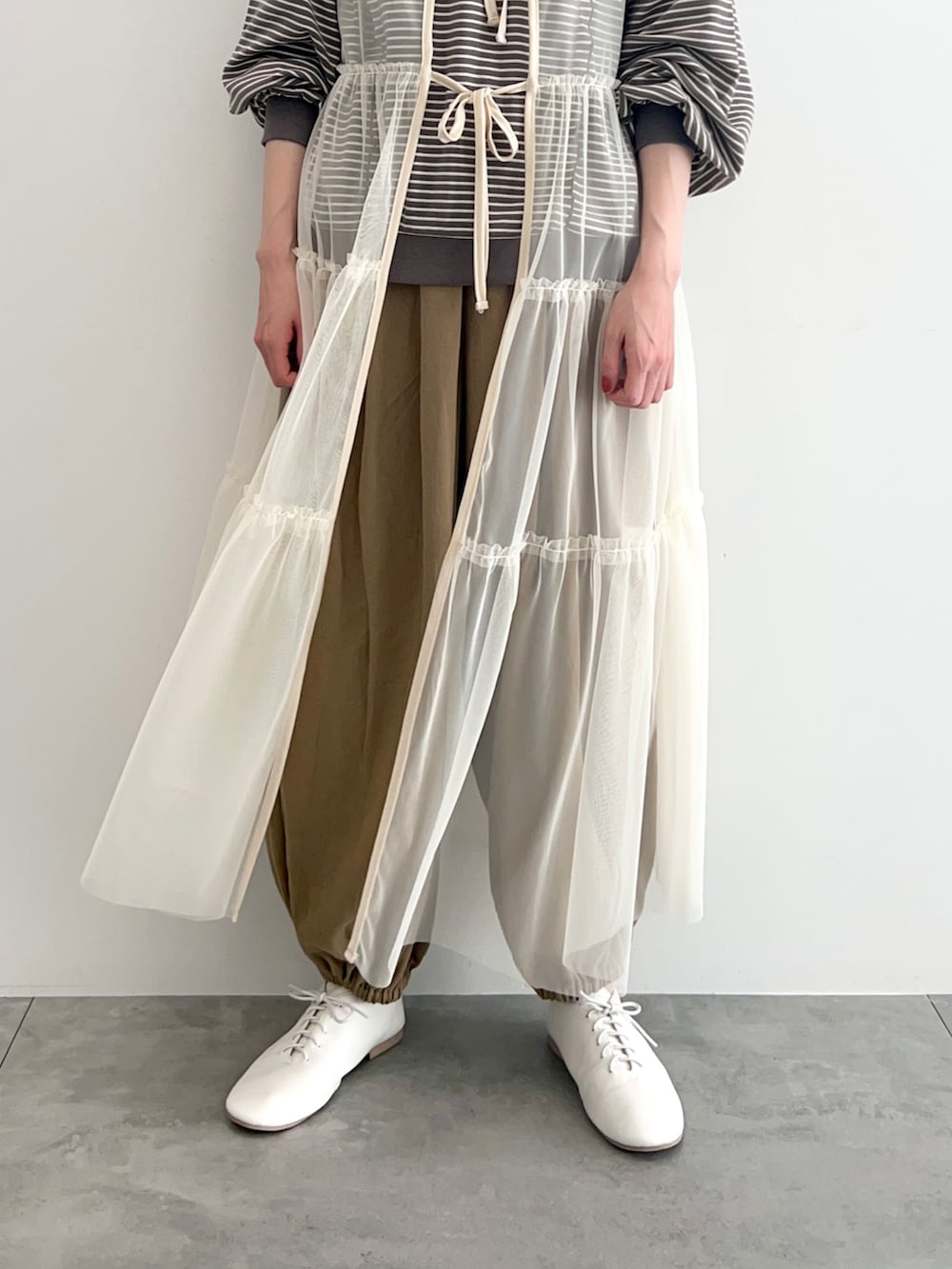 ブラウン系のTシャツ/カットソー、ホワイト系のワンピース、ベージュ系のその他パンツを着用したレディースの春コーディネートの4枚目の写真