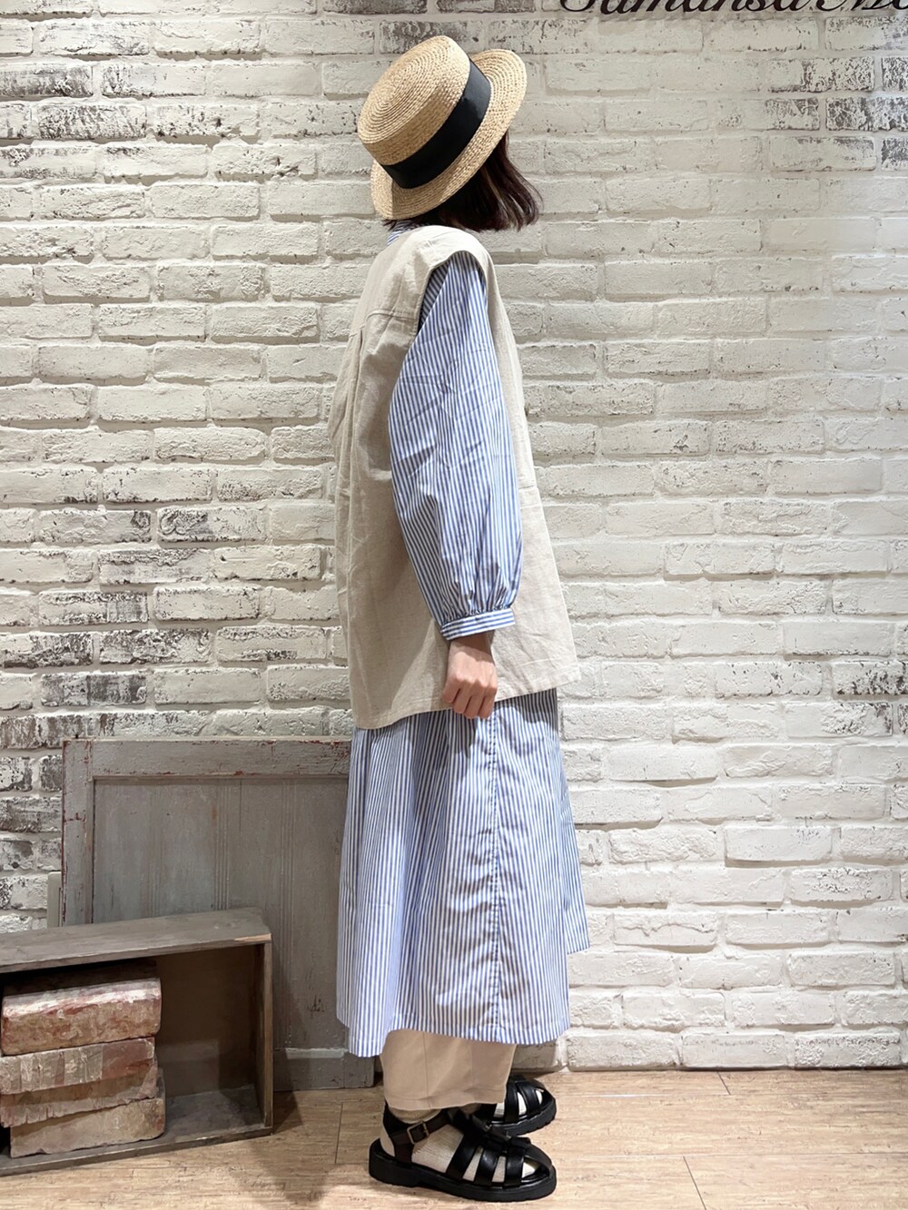 ホワイト系のベスト、ブラック系のハンドバッグ、ブルー系のシャツワンピースを着用したレディースの春コーディネートの3枚目の写真