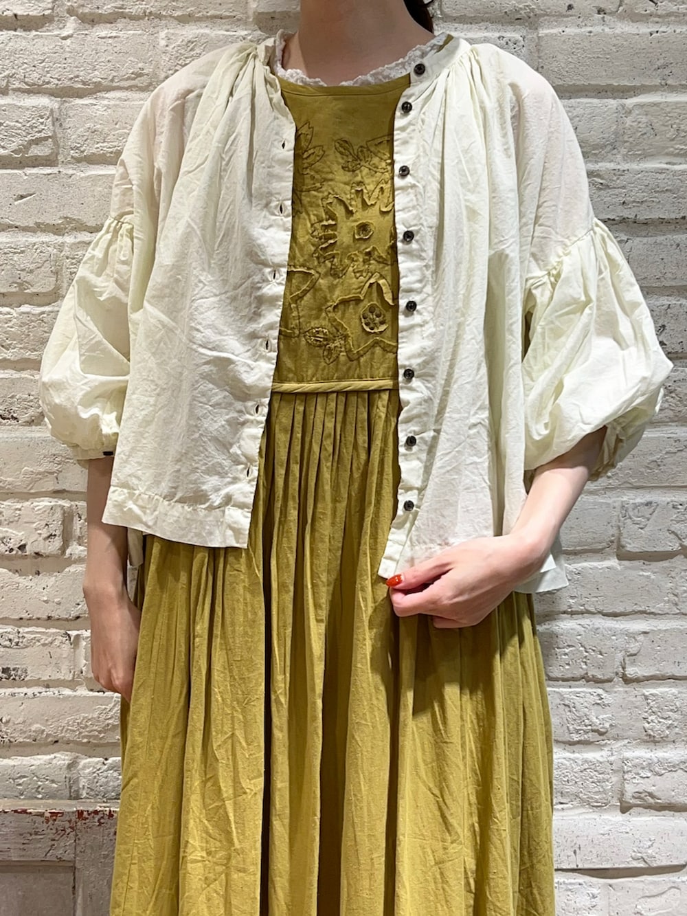 ホワイト系のタンクトップ、イエロー系のシャツ/ブラウス、グリーン系のワンピースを着用したレディースの春コーディネートの2枚目の写真