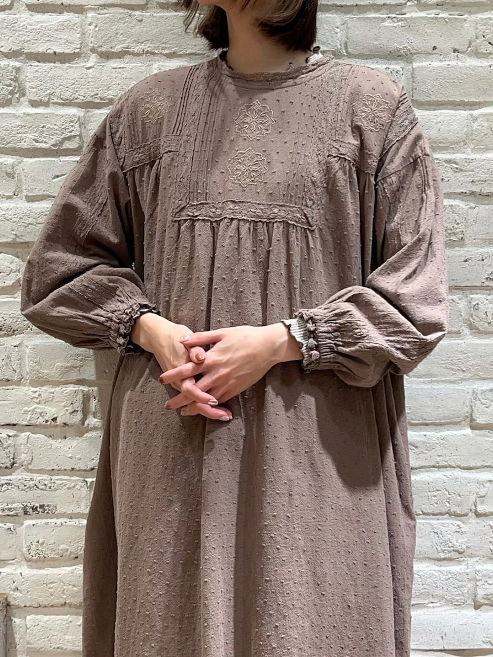 ブラウン系のワンピース、ブラウン系のワンピース、ブラウン系のハンドバッグを着用したレディースの冬コーディネートの3枚目の写真