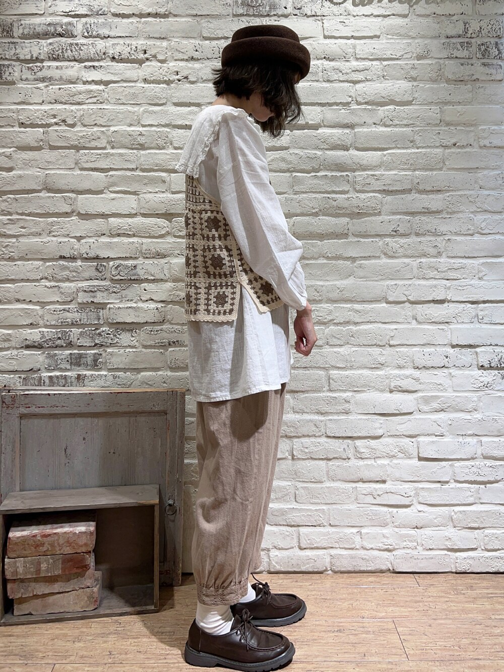 ホワイト系のチュニック、ホワイト系のベスト、ベージュ系のショルダーバッグを着用したレディースの秋コーディネートの3枚目の写真