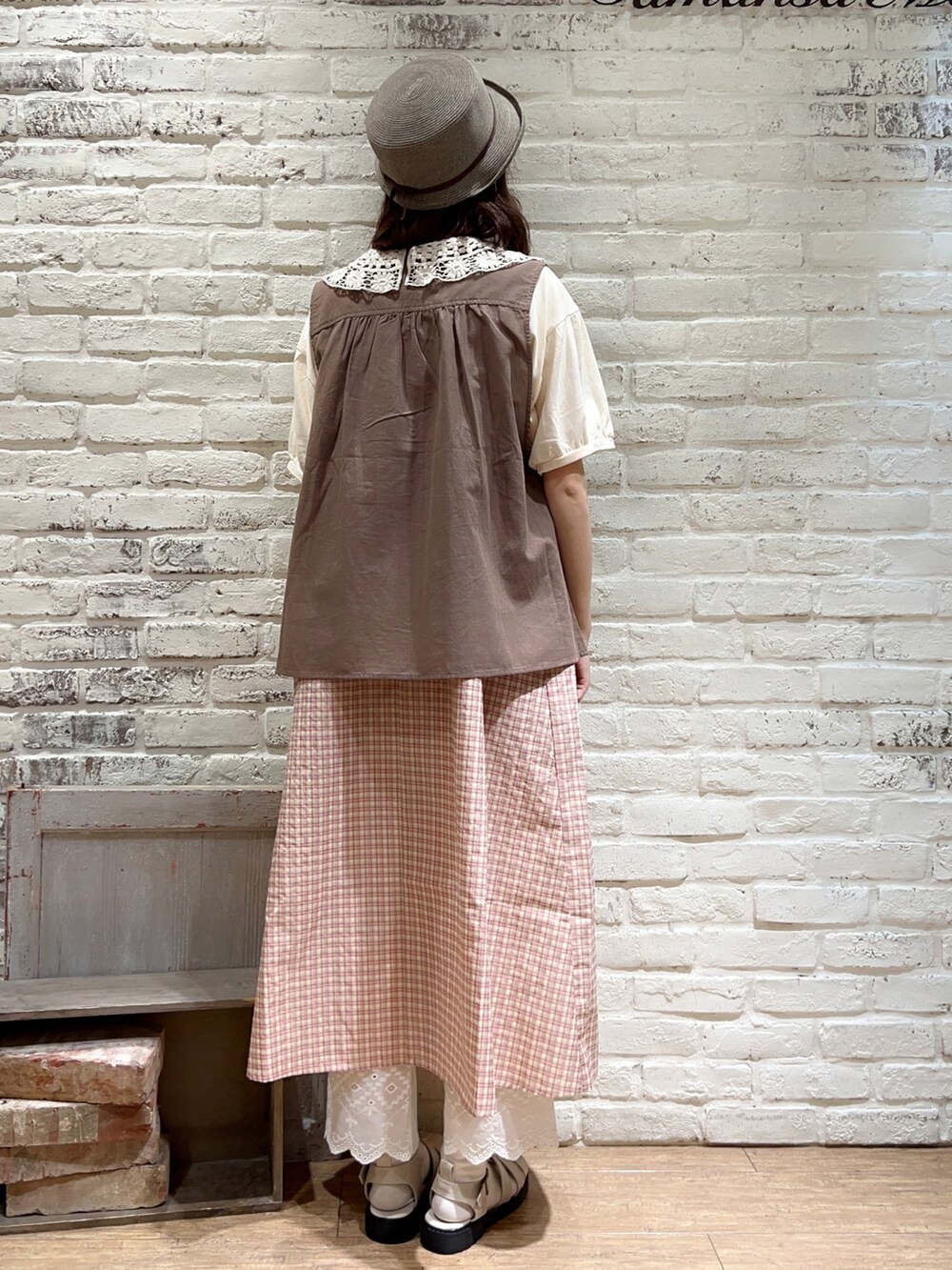 ホワイト系のTシャツ/カットソー、ブラウン系のベスト、ブラウン系のハンドバッグを着用したレディースの秋コーディネートの4枚目の写真