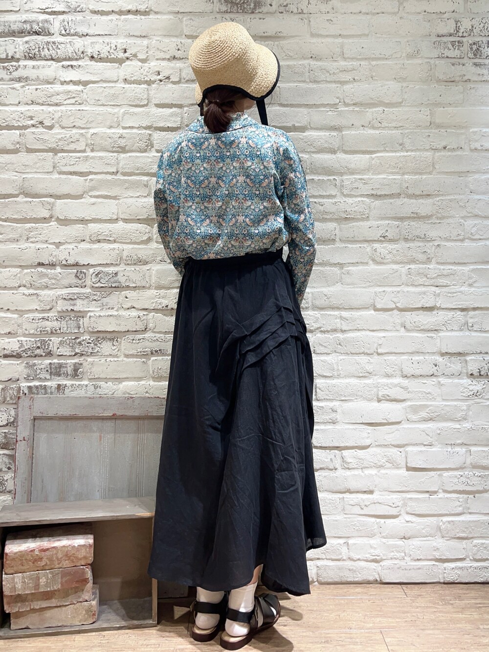 グリーン系のシャツ/ブラウス、ブラック系のスカート、ブラック系のサンダルを着用したレディースの春コーディネートの5枚目の写真