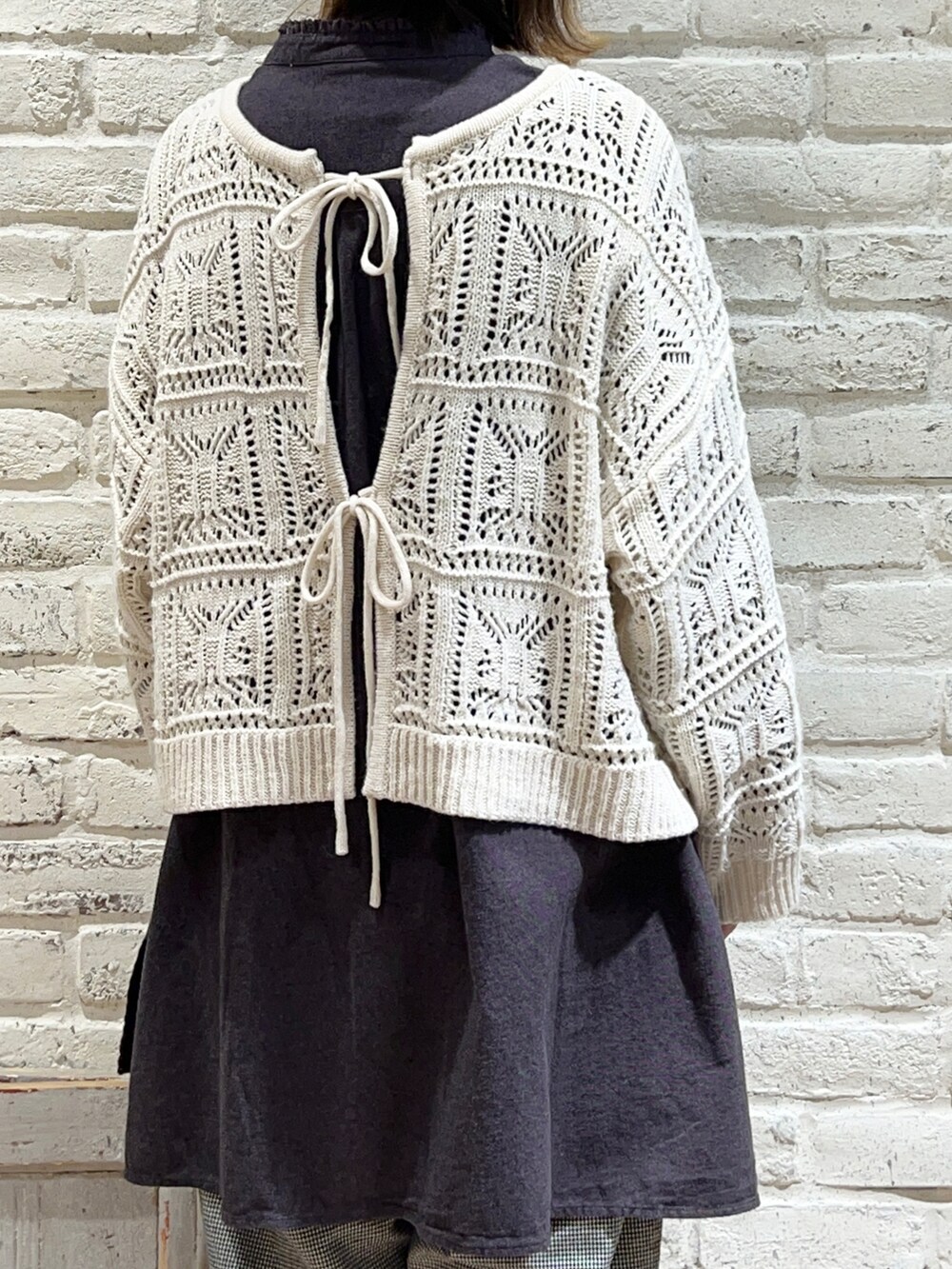 ホワイト系のニット/セーター、グレー系のチュニック、ブラック系のその他パンツを着用したレディースの冬コーディネートの5枚目の写真