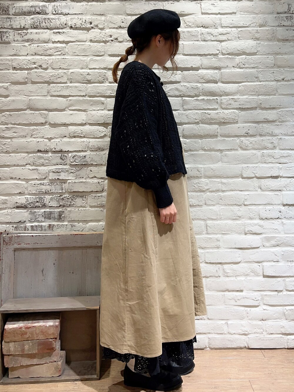 ホワイト系のシャツ/ブラウス、ブラック系のカーディガン/ボレロ、ベージュ系のジャンパースカートを着用したレディースの秋コーディネートの4枚目の写真