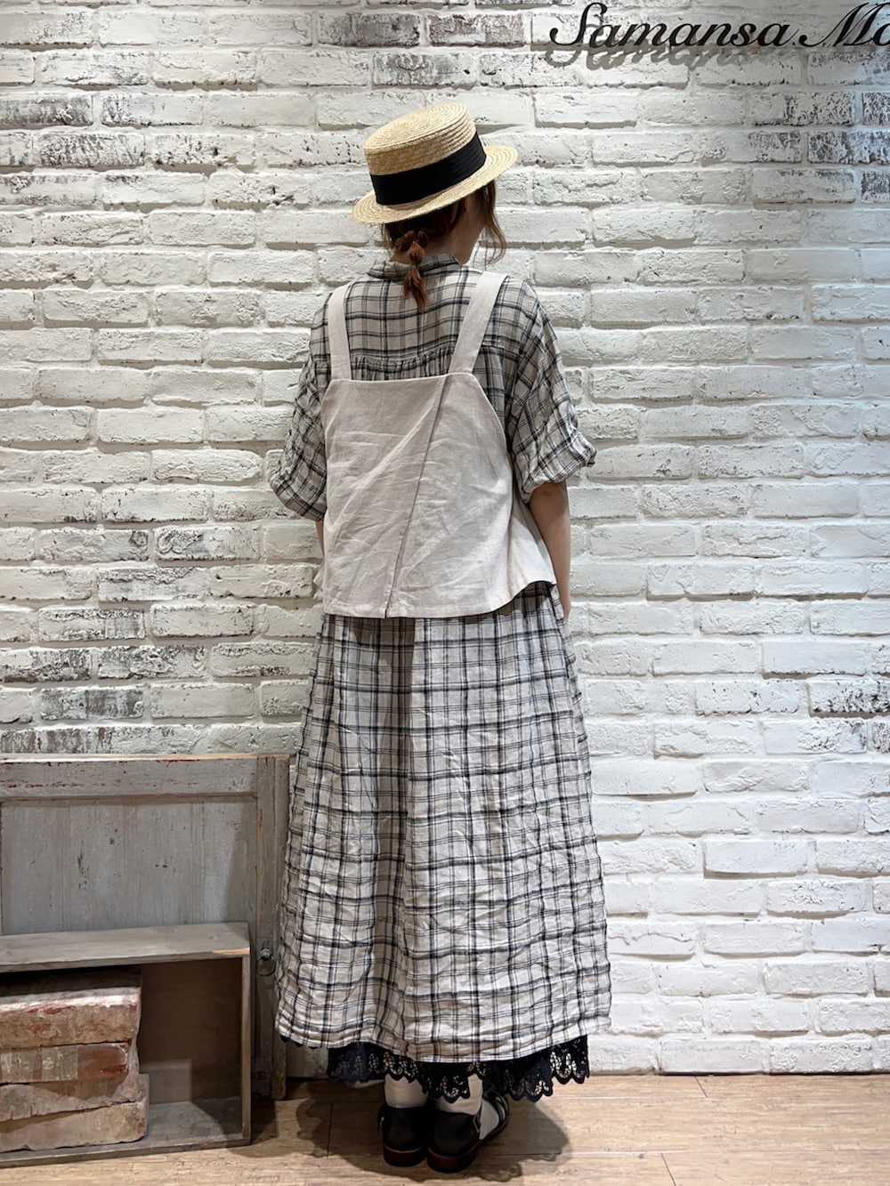 ベージュ系のベスト、ホワイト系のワンピース、ブラック系のスカートを着用したレディースの夏コーディネートの4枚目の写真