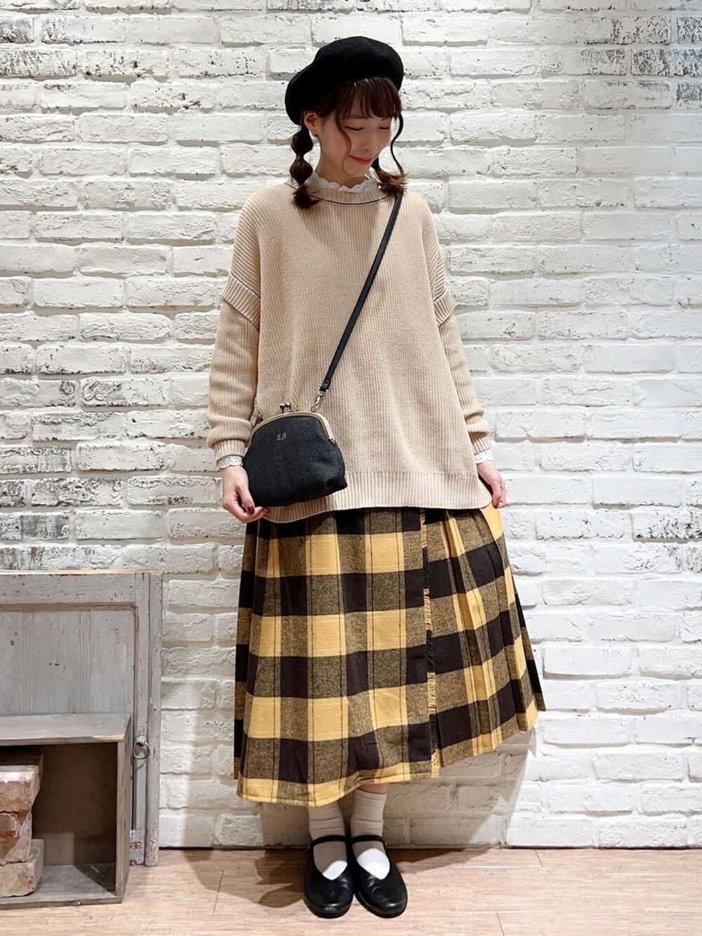 ホワイト系のTシャツ/カットソー、ブラウン系のポンチョ、ホワイト系のニット/セーターを着用したレディースの秋コーディネートの3枚目の写真