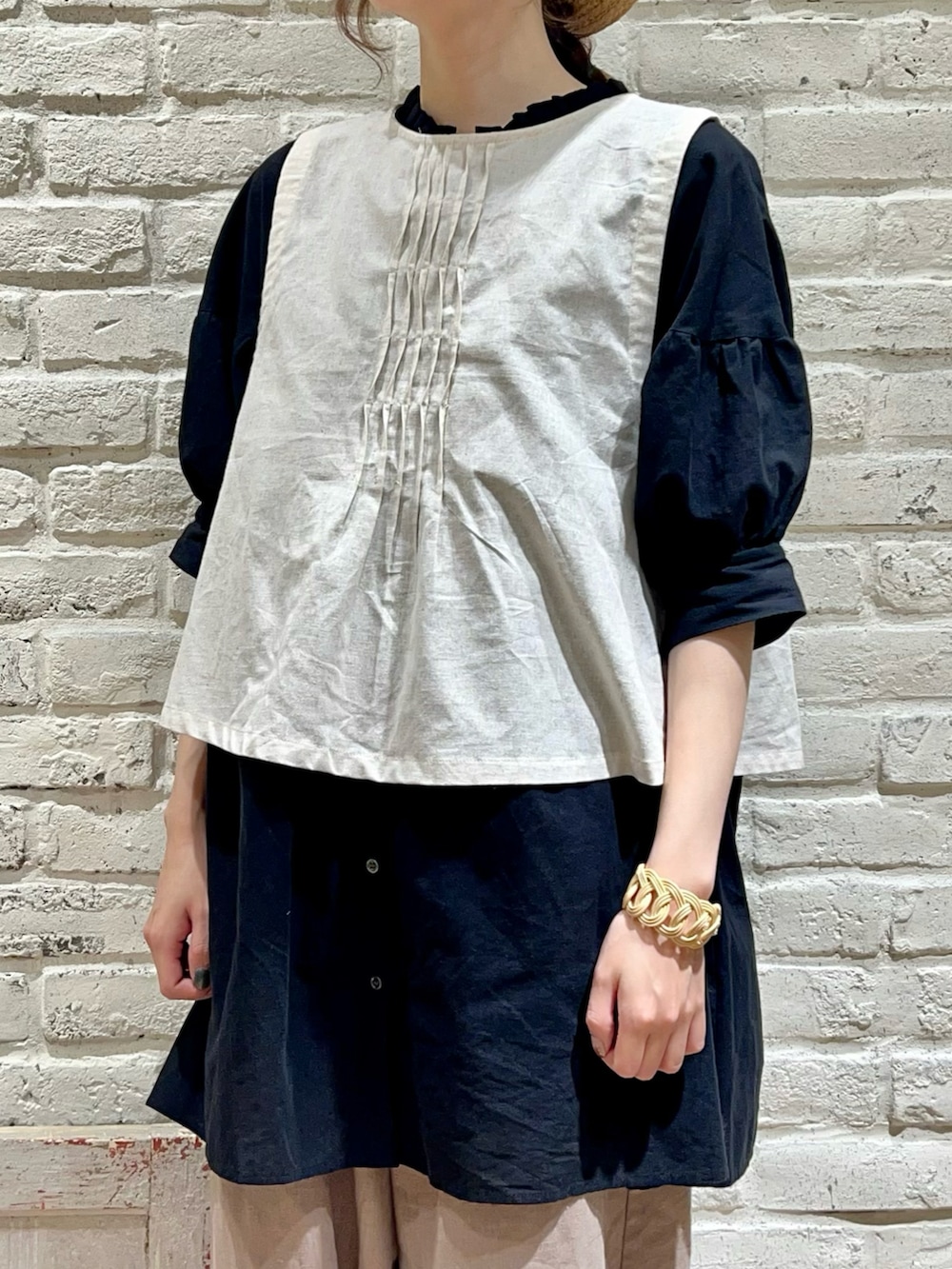 ホワイト系のベスト、ブラック系のチュニック、ブラウン系のその他パンツを着用したレディースの夏コーディネートの4枚目の写真