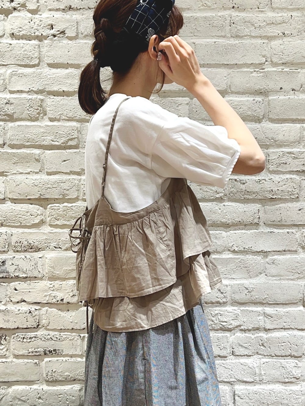 ホワイト系のTシャツ/カットソー、ベージュ系のシャツ/ブラウス、グレー系のハンドバッグを着用したレディースの秋コーディネートの3枚目の写真