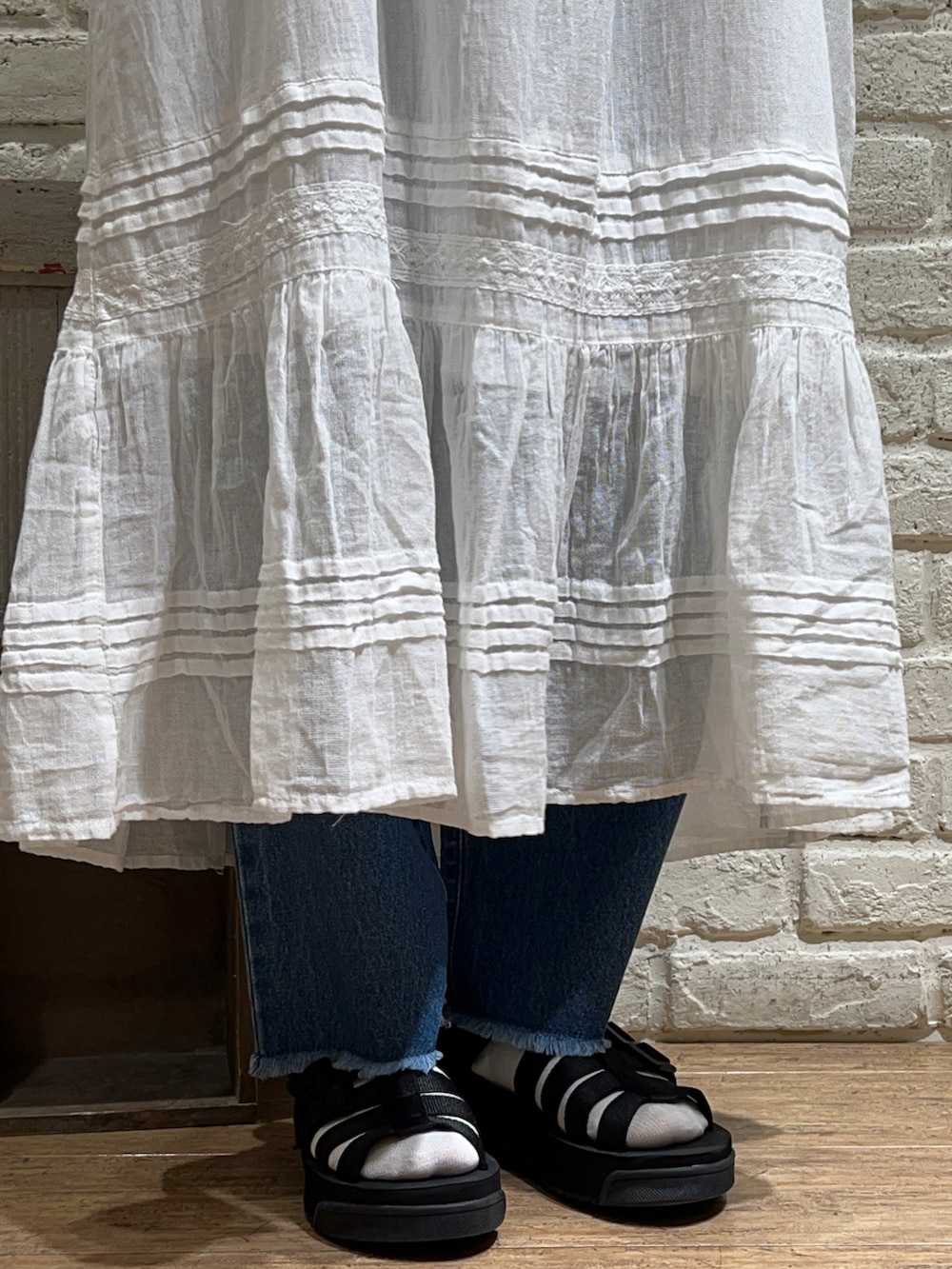 グレー系のTシャツ/カットソー、ホワイト系のワンピース、グレー系のハンドバッグを着用したレディースの秋コーディネートの5枚目の写真