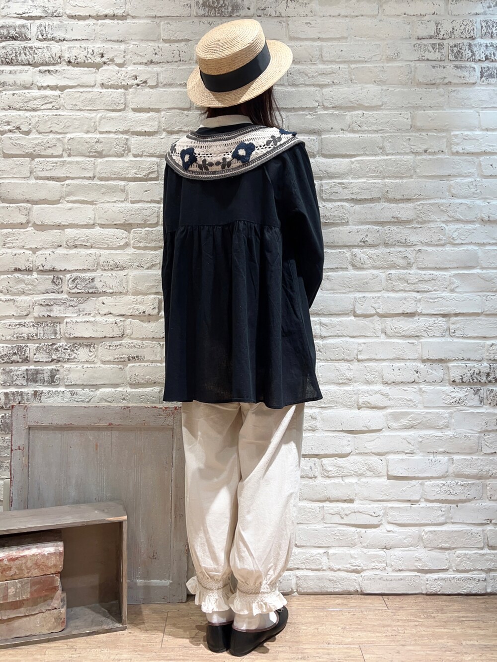 ブラック系のチュニック、ホワイト系のハンドバッグ、ホワイト系のその他パンツを着用したレディースの春コーディネートの4枚目の写真