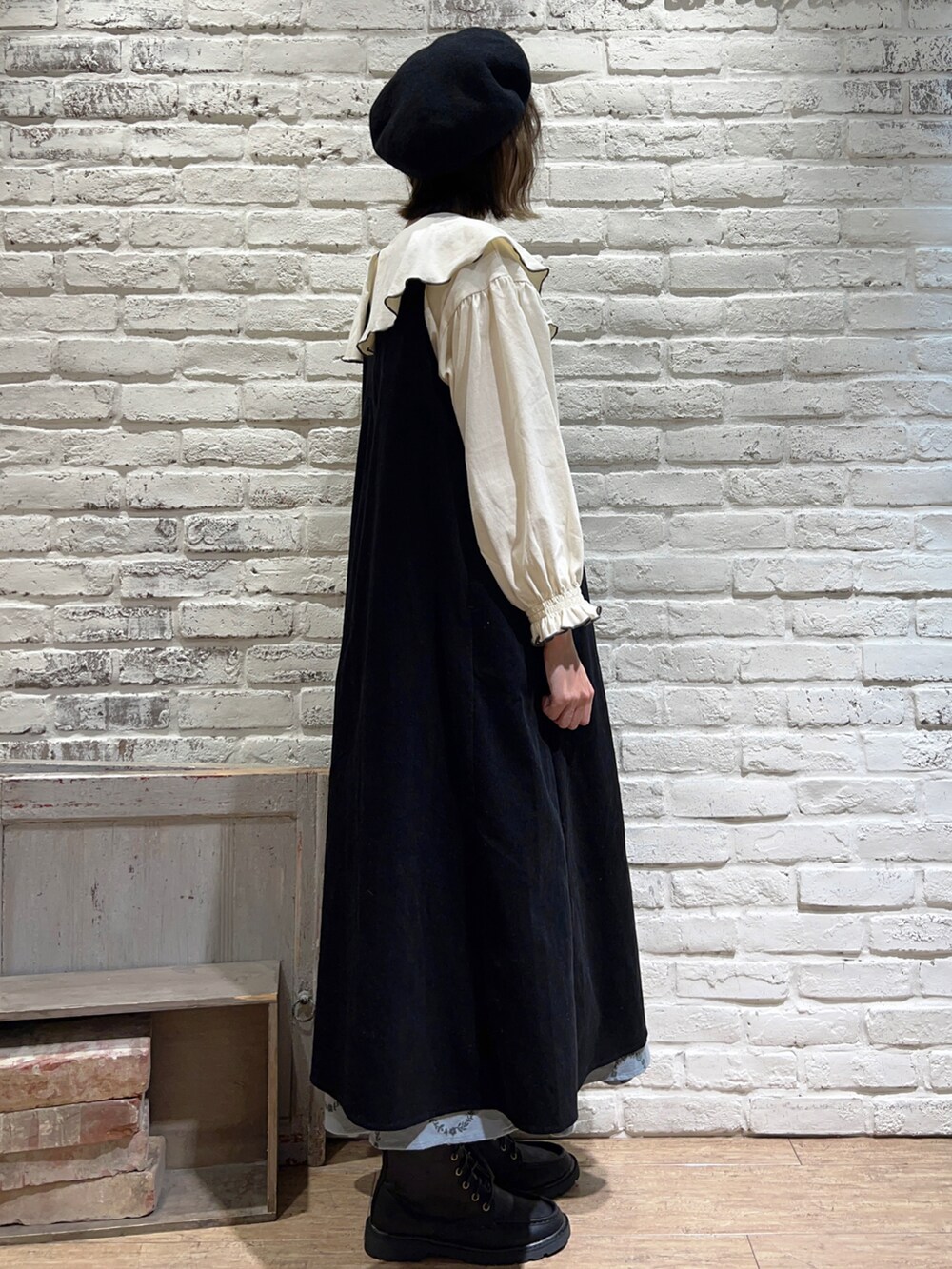 グレー系のTシャツ/カットソー、ブラック系のジャンパースカート、ブルー系のスカートを着用したレディースの秋コーディネートの3枚目の写真