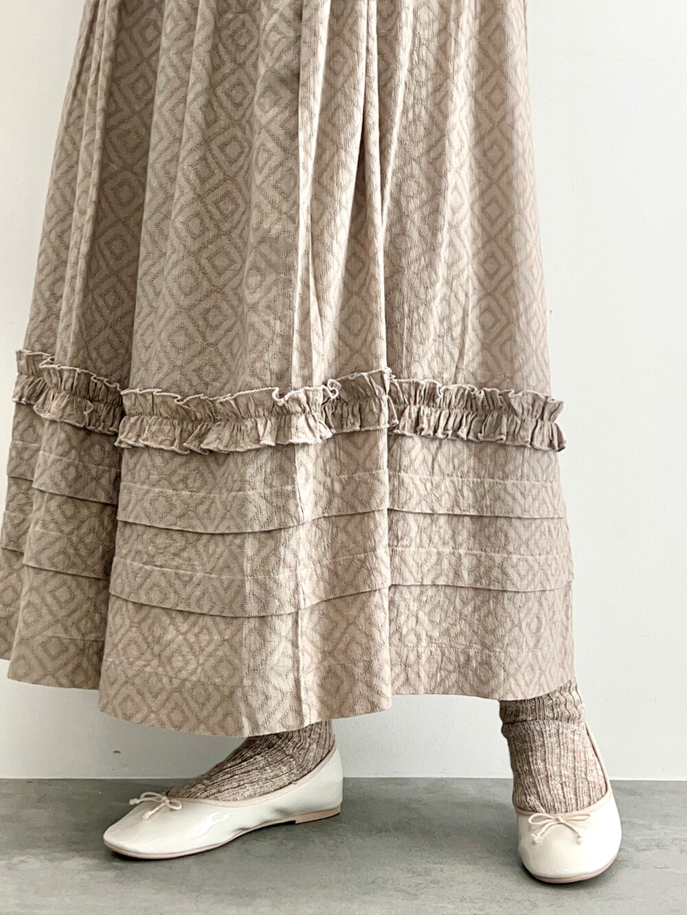 グレー系のスカート、ホワイト系のパンプス、ベージュ系のシャツ/ブラウスを着用したレディースの春コーディネートの5枚目の写真