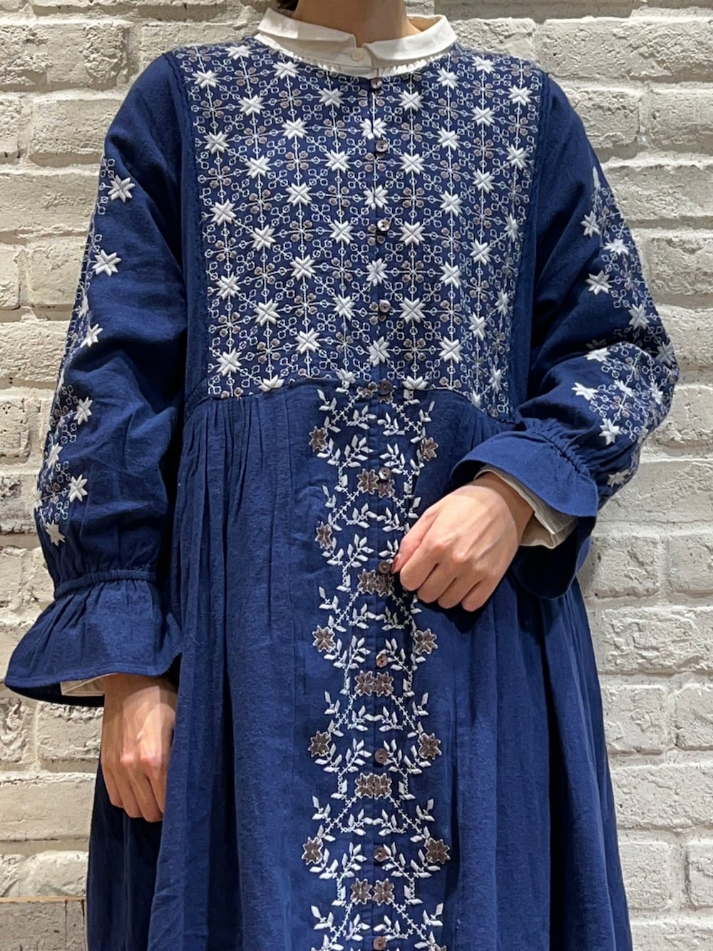 ホワイト系のシャツ/ブラウス、ブルー系のワンピース、ベージュ系のブーツを着用したレディースの冬コーディネートの2枚目の写真