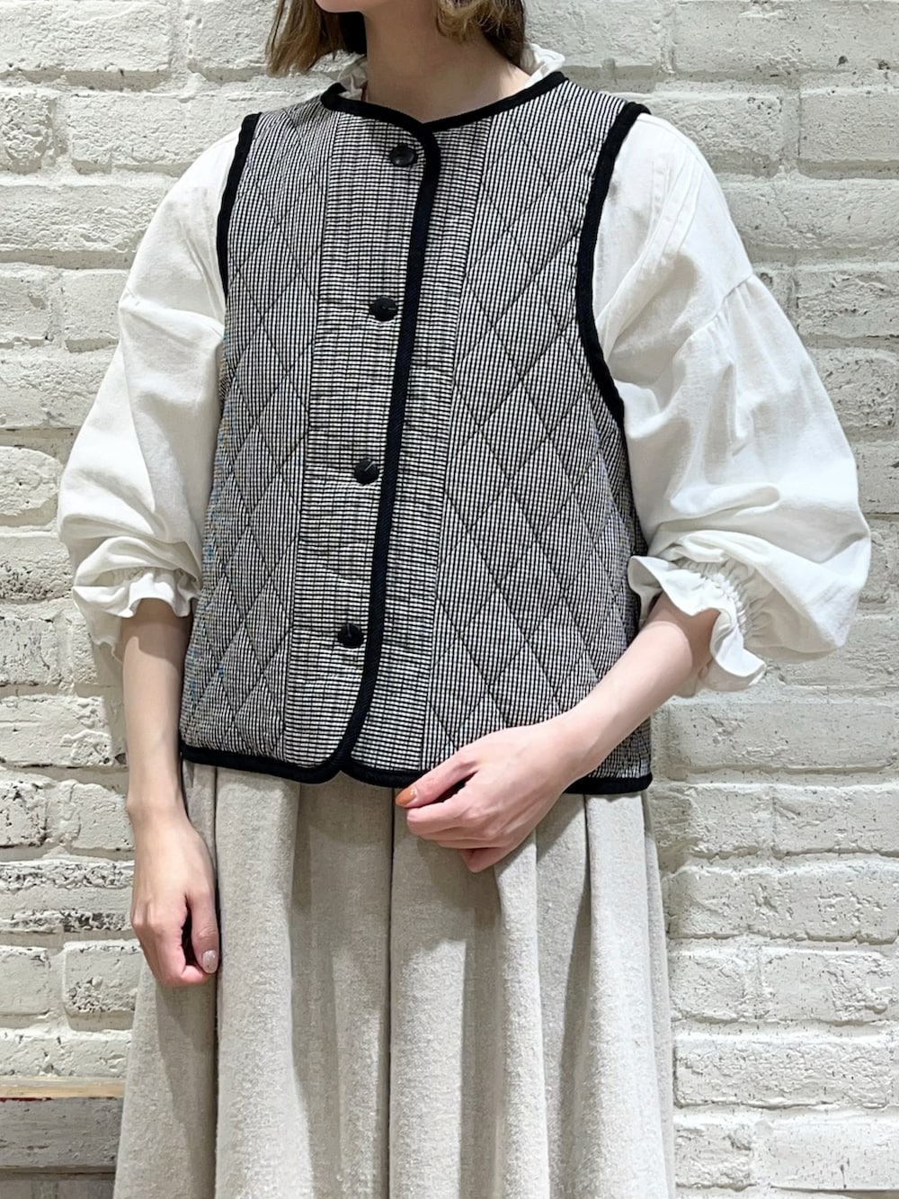 グレー系のその他アウター、ブラック系のベスト、ホワイト系のシャツ/ブラウスを着用したレディースの冬コーディネートの3枚目の写真