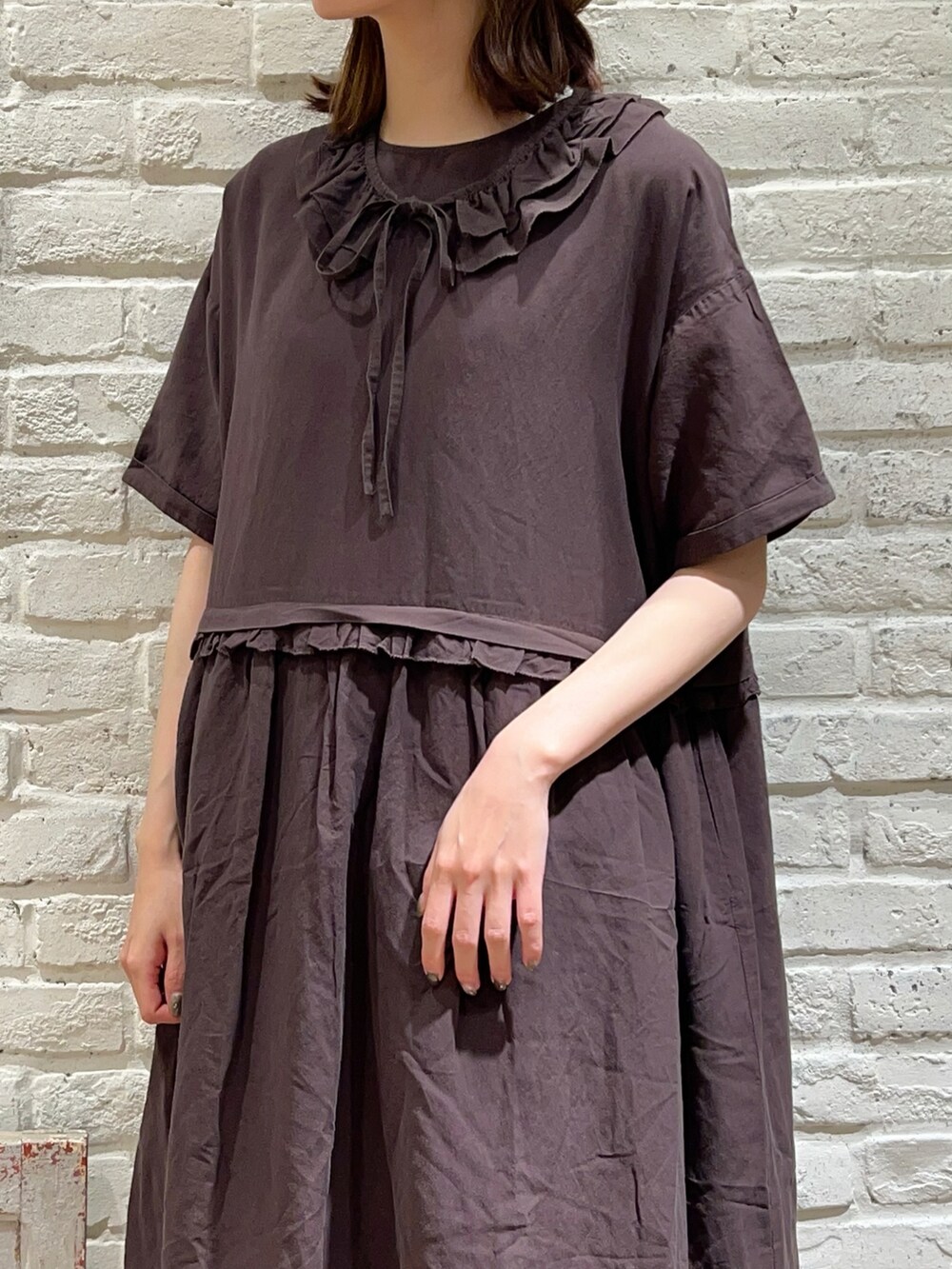 グレー系のワンピース、ブラック系のハンドバッグ、ブラック系のスカートを着用したレディースの春コーディネートの2枚目の写真